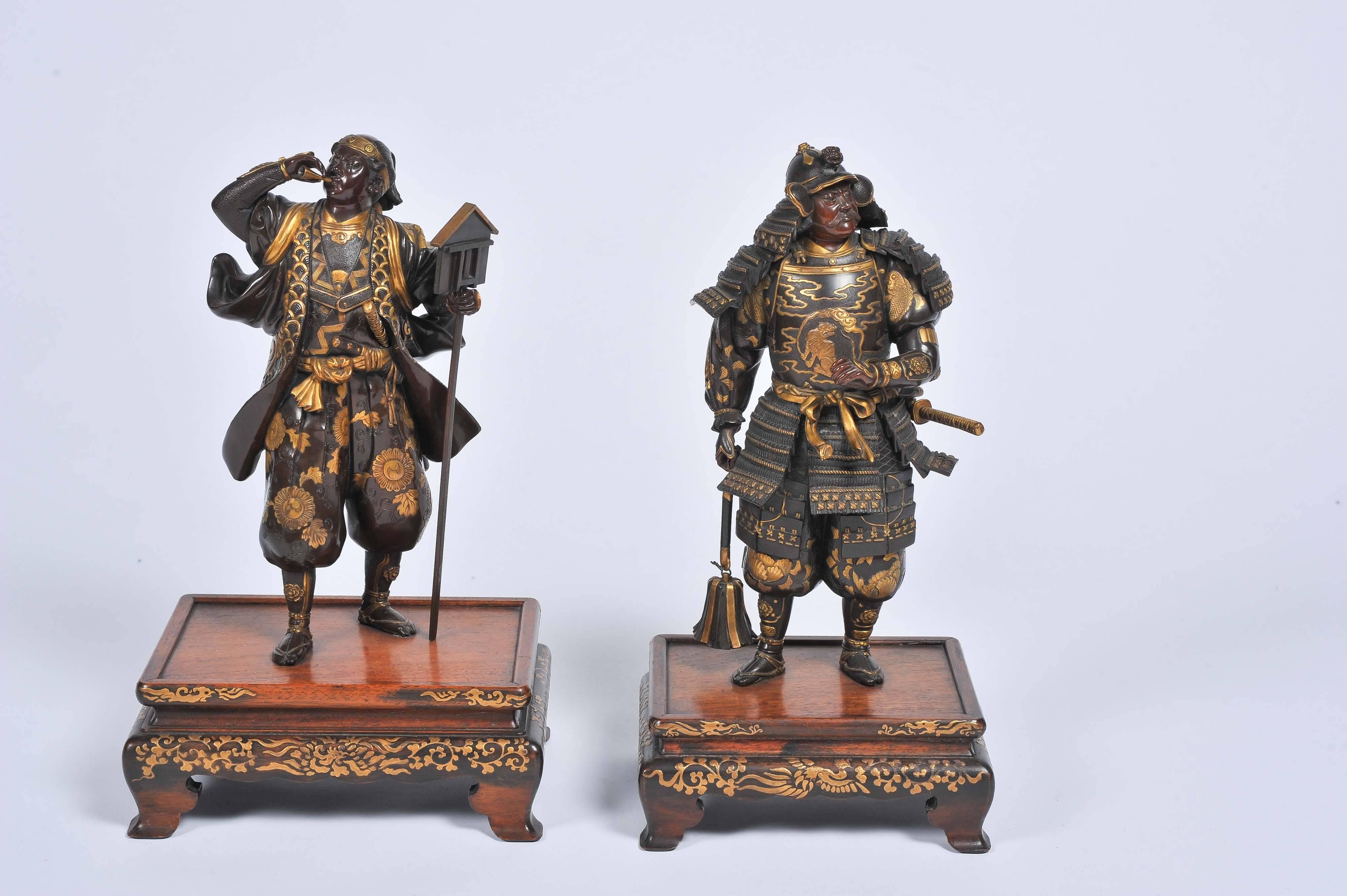 A fine quality near pair of Japanese Meiji period bronze Samurai warriors, having gilded relief decoration and mounted on hardwood stands.