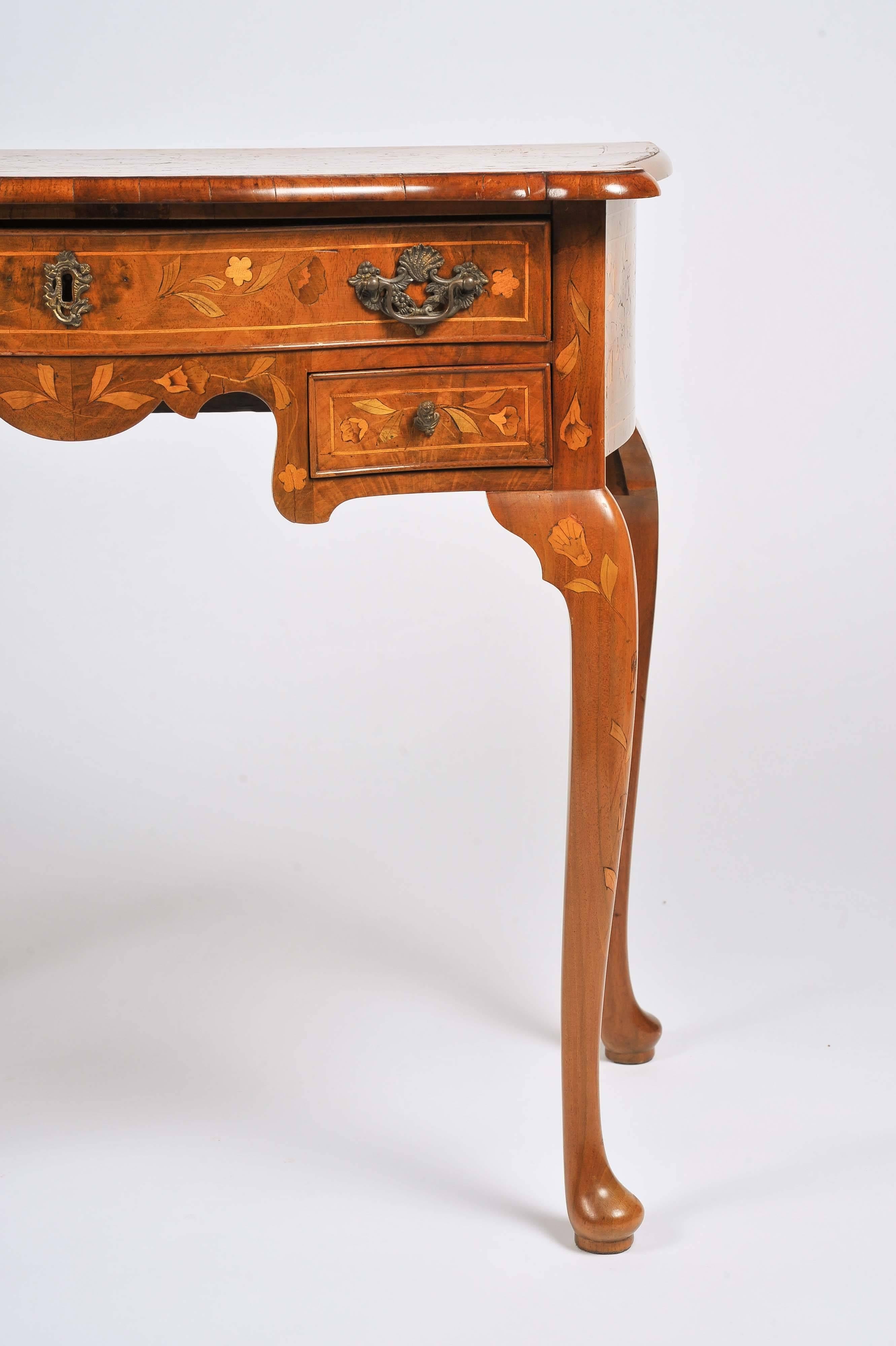 A very good quality 18th century Dutch marquetry serpentine fronted walnut side table. Having classical floral inlaid decoration, one long and two short drawers raised on inlaid cabriole legs, terminating in small pad feet.