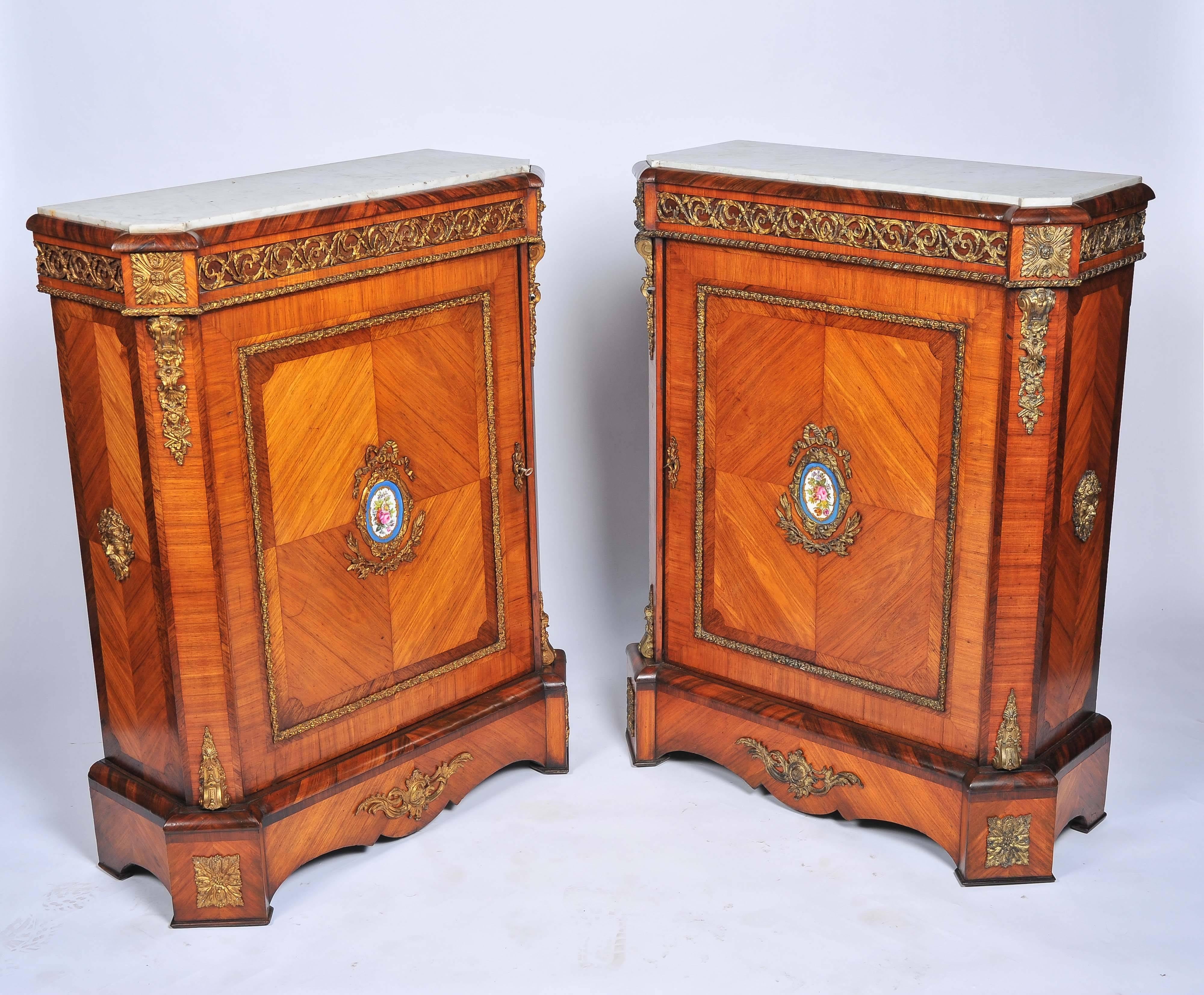 A good quality pair of 19th century French kingwood, ormolu-mounted pier cabinets, each with the original marble tops and 'Sevres' porcelain plaques to the doors.