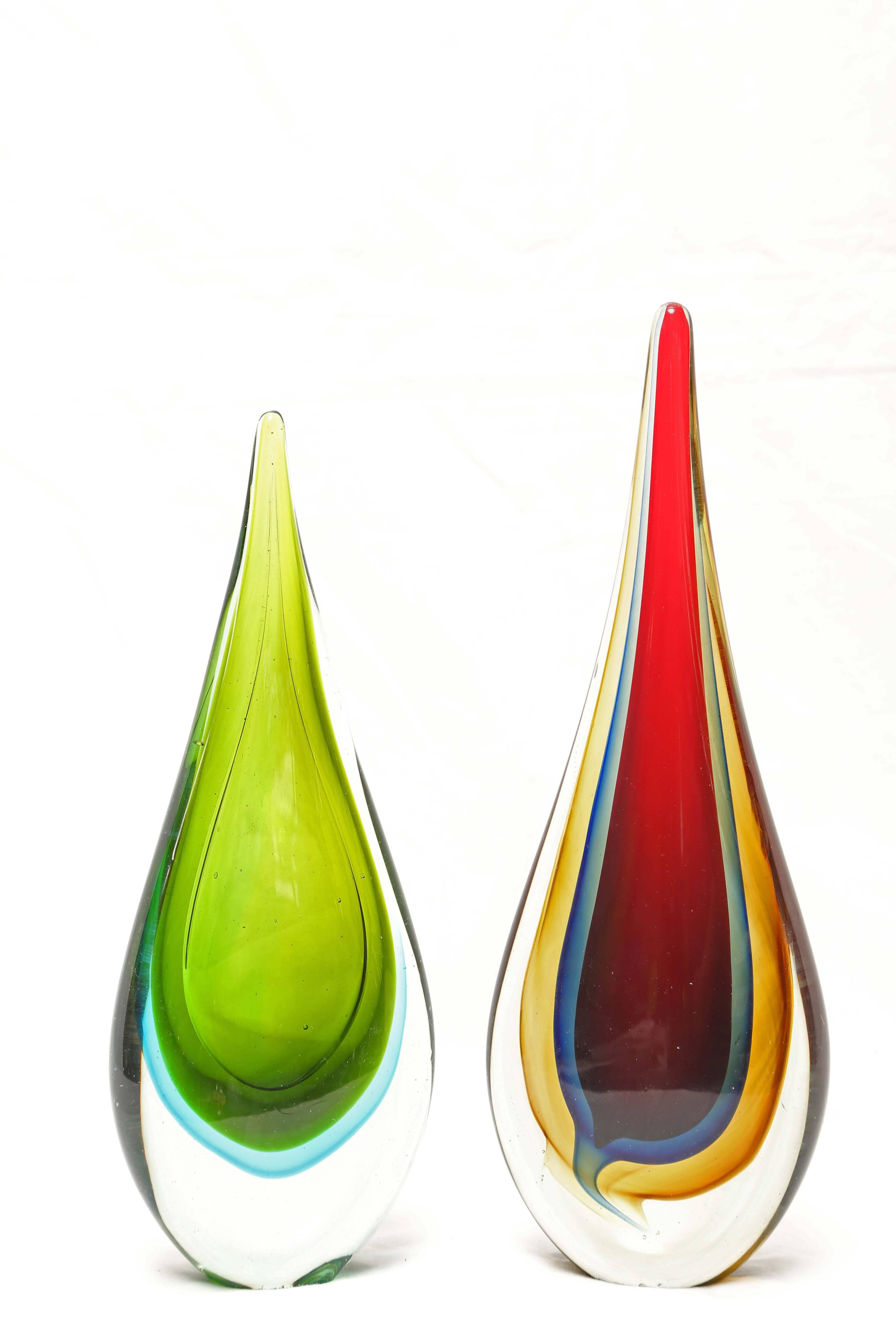 You are looking at two Italian Murano Sommerso glass teardrop sculptures in the style of Flávio Poli for Seguso. These are quite stunning in person. The larger of the two is primarily in red with a grayish blue and golden color all encased in a