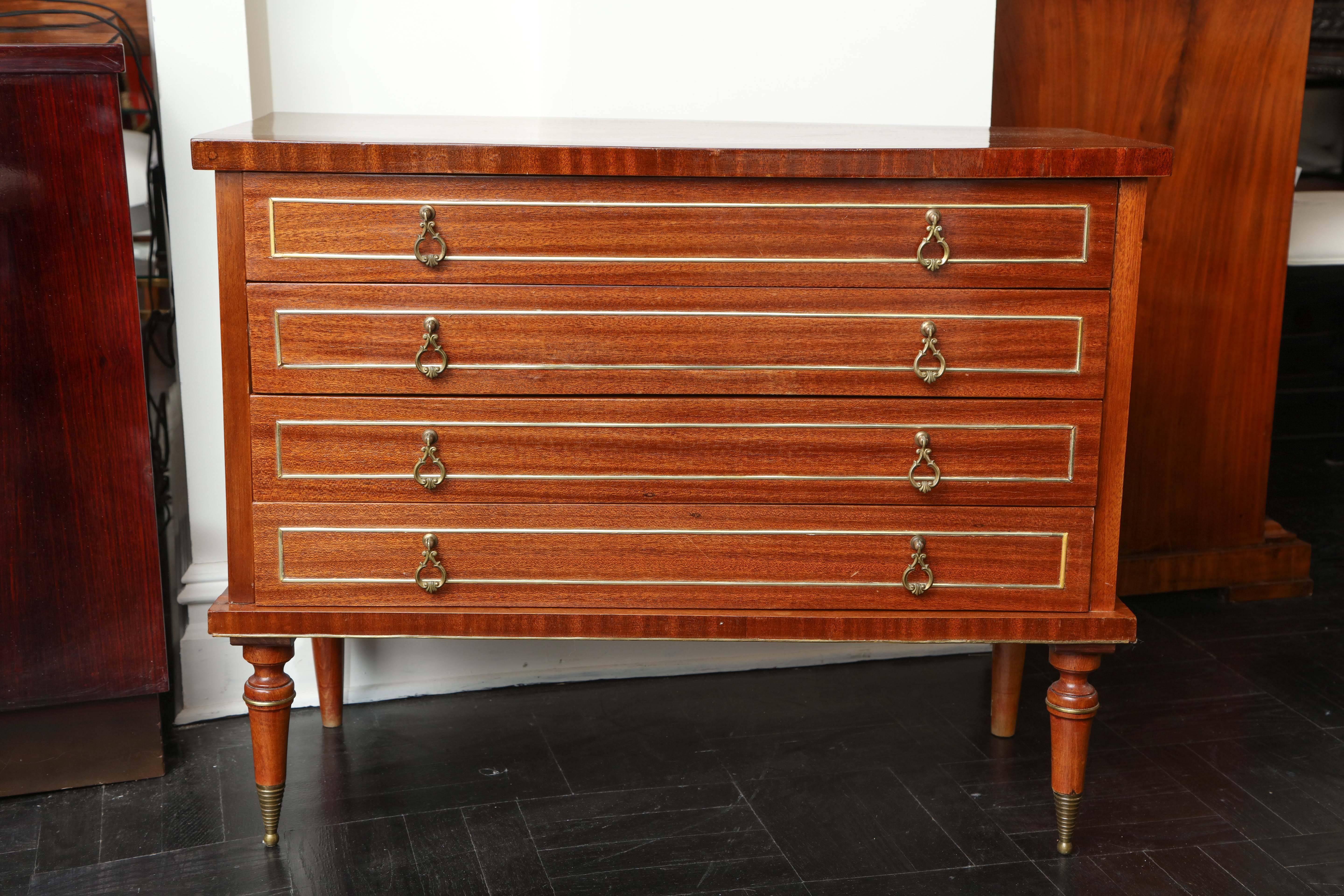 Early 20th century mahogany four-drawer commode, decorated paneling, molded polished top, ring turned legs,
French, circa 1930-1940.