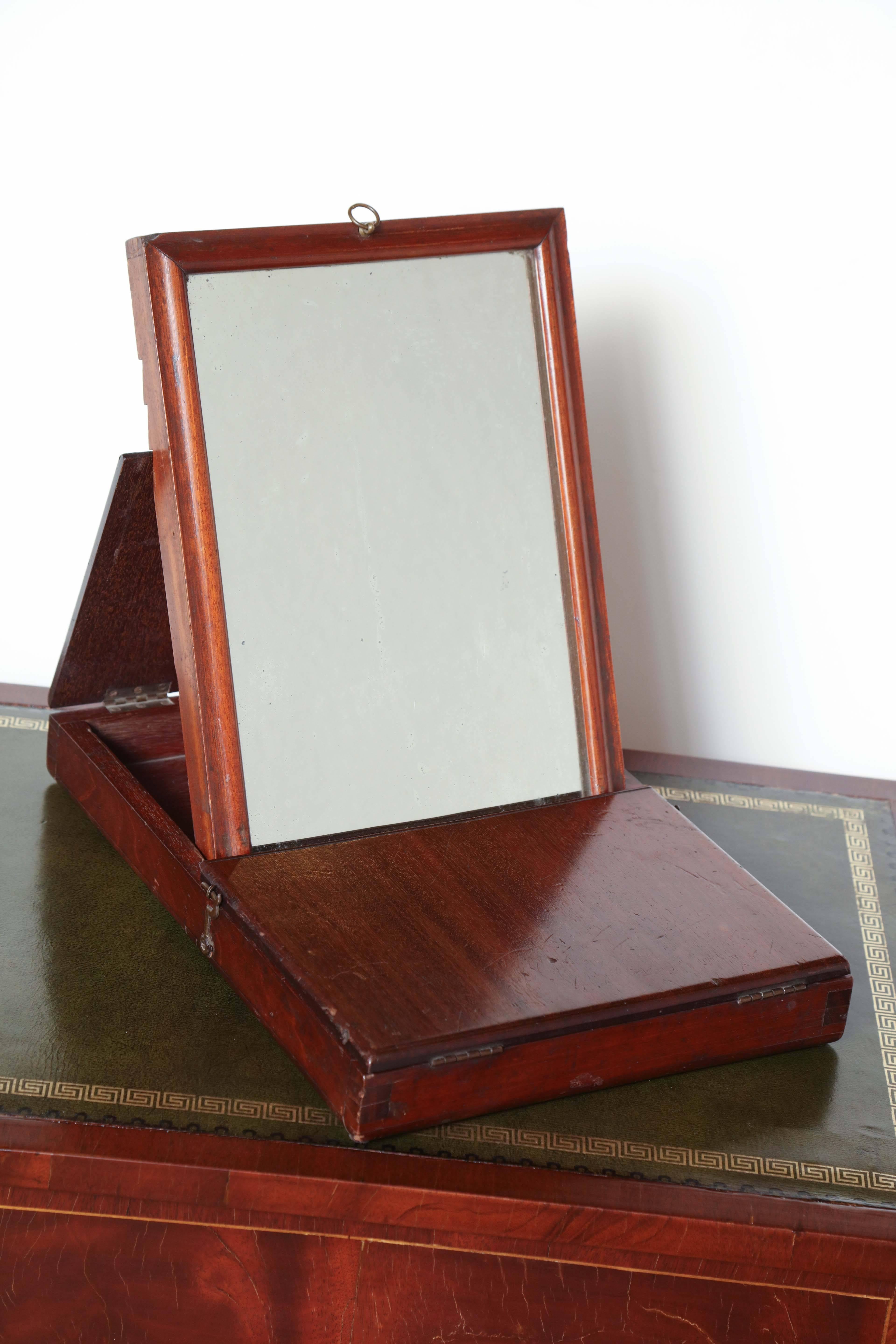 19th century English campaign mirror in mahogany box with two flaps and adjustable mirror.