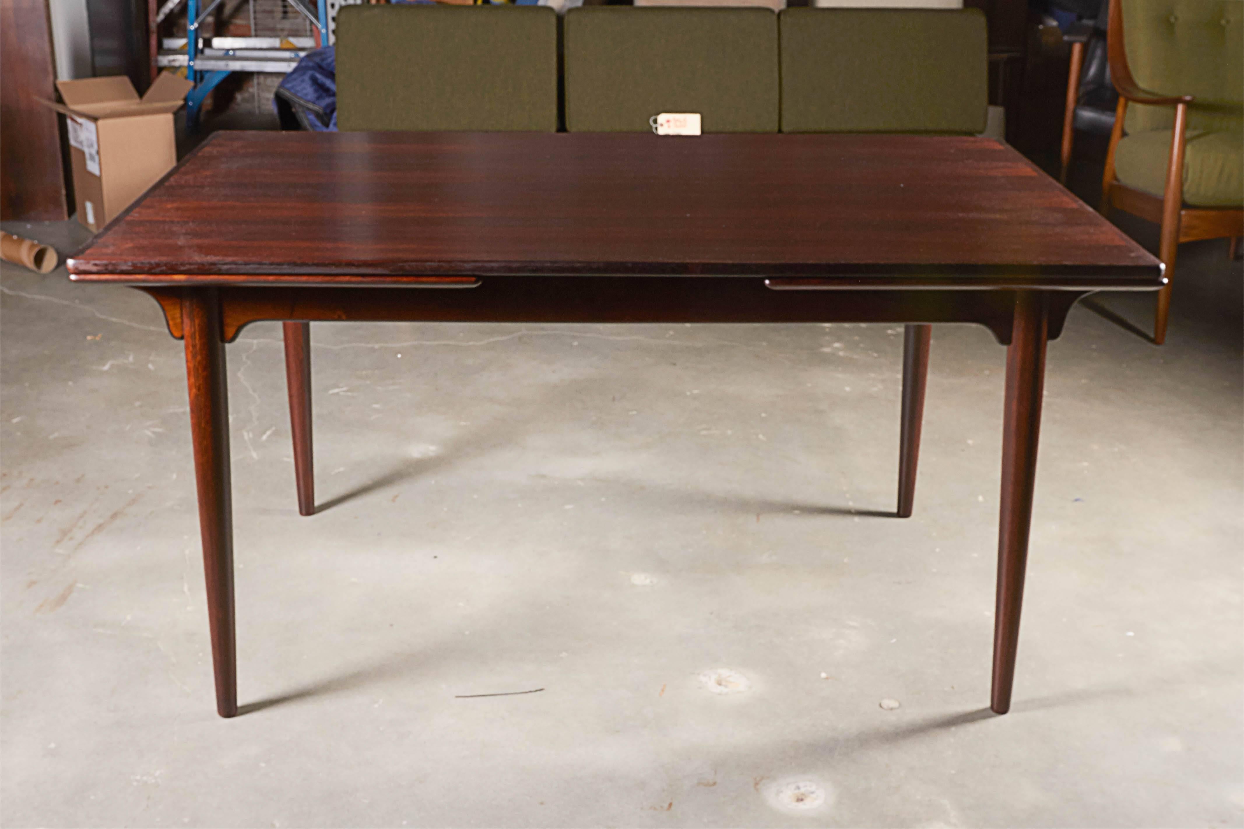 Vintage Danish Modern Dining Table in Rosewood by Omann Jun

This expandable dining table has leaves on each side that sit under the table then just easily slide right out when you want to use them. Each leaf is 21.25" wide which seats eight