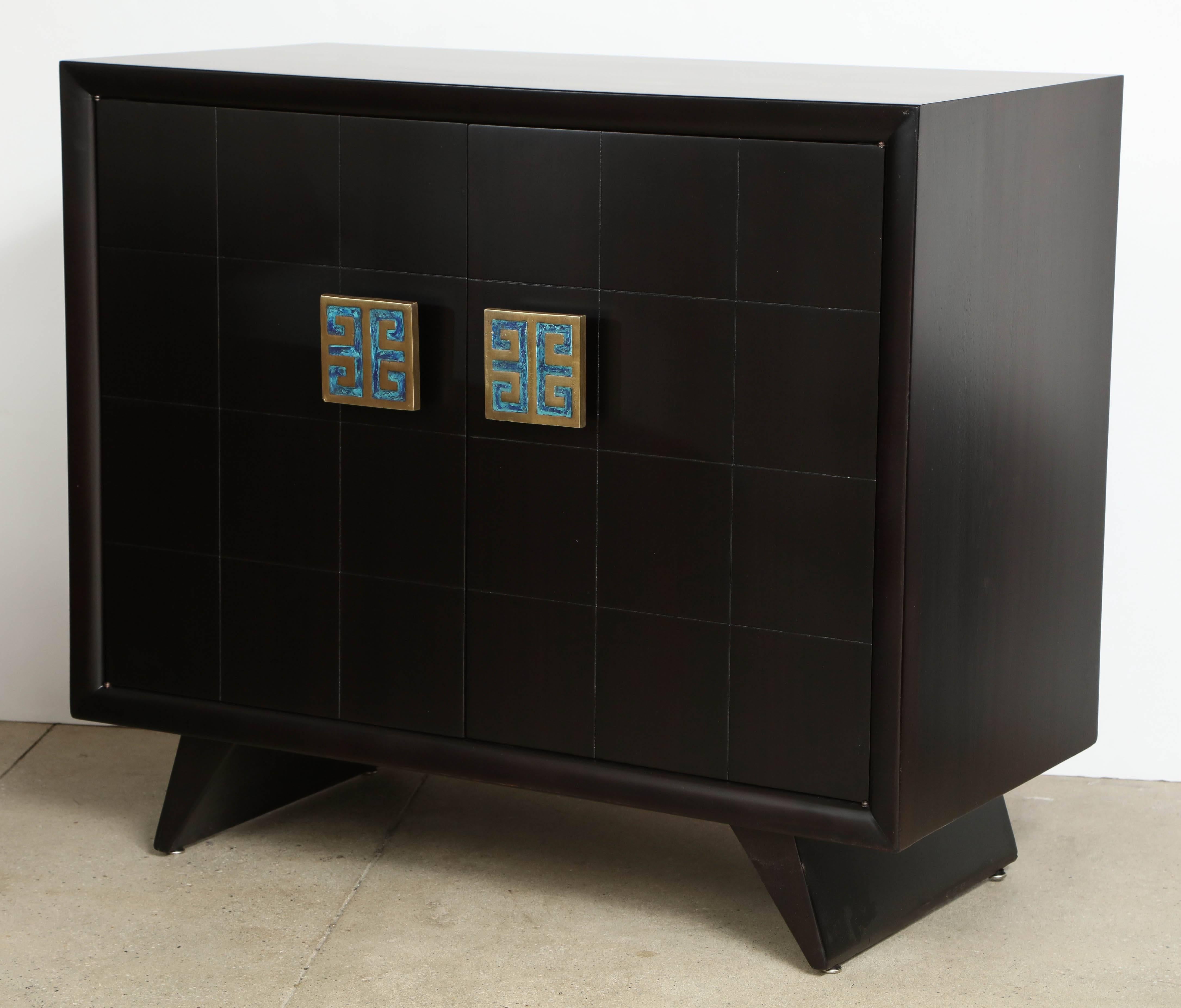 Pair of matte finished ebonized mahogany cabinets by Grosfeld House of New York with large Pepe Mendoza bronze pulls with blue and green enamel. Cabinets have two doors which conceal four pull-out drawers. Mint restored.
Partial foil label to