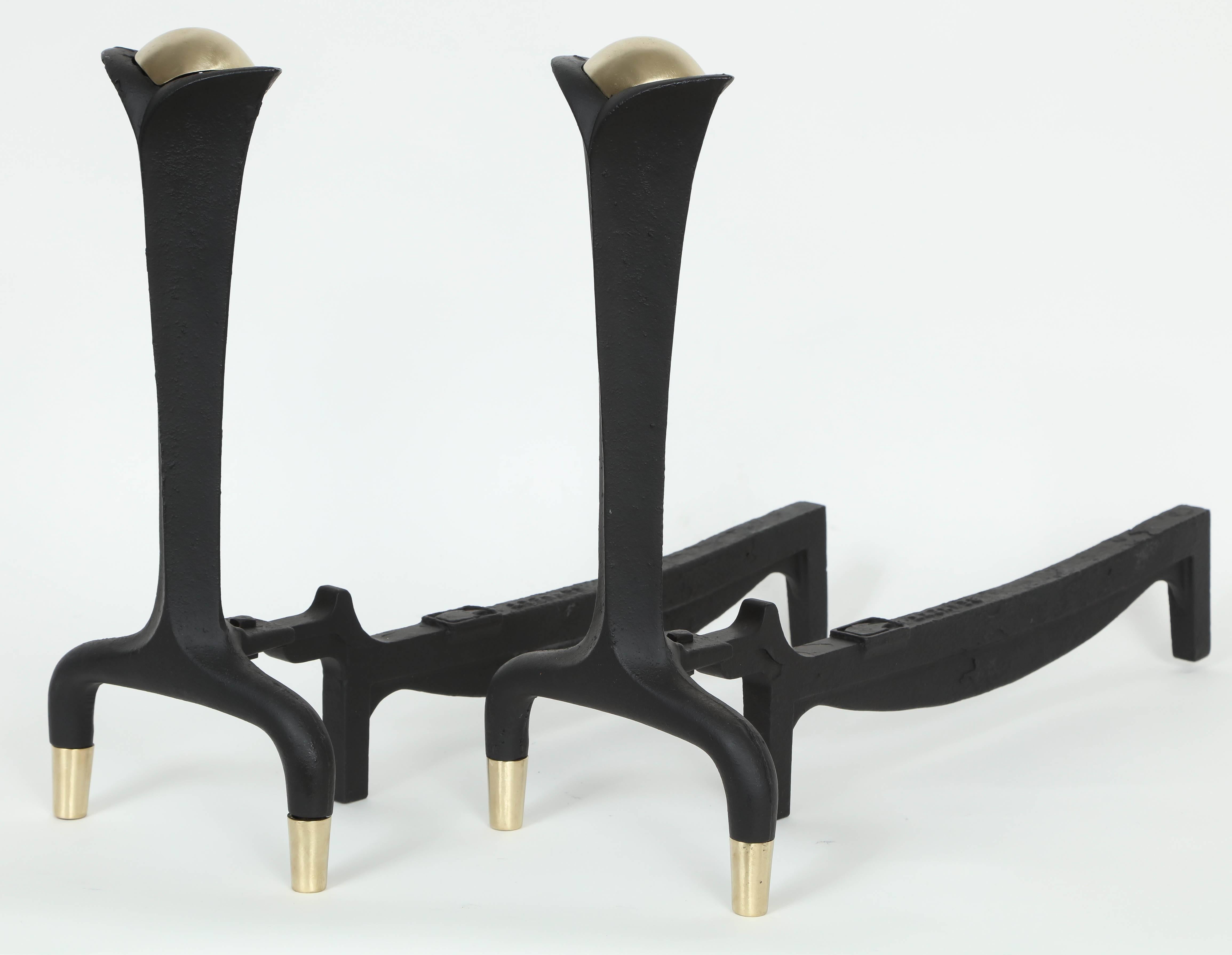 Pair of blackened cast iron andirons with satin brass band wrapped legs and centre. Donald Deskey for Bennett Co