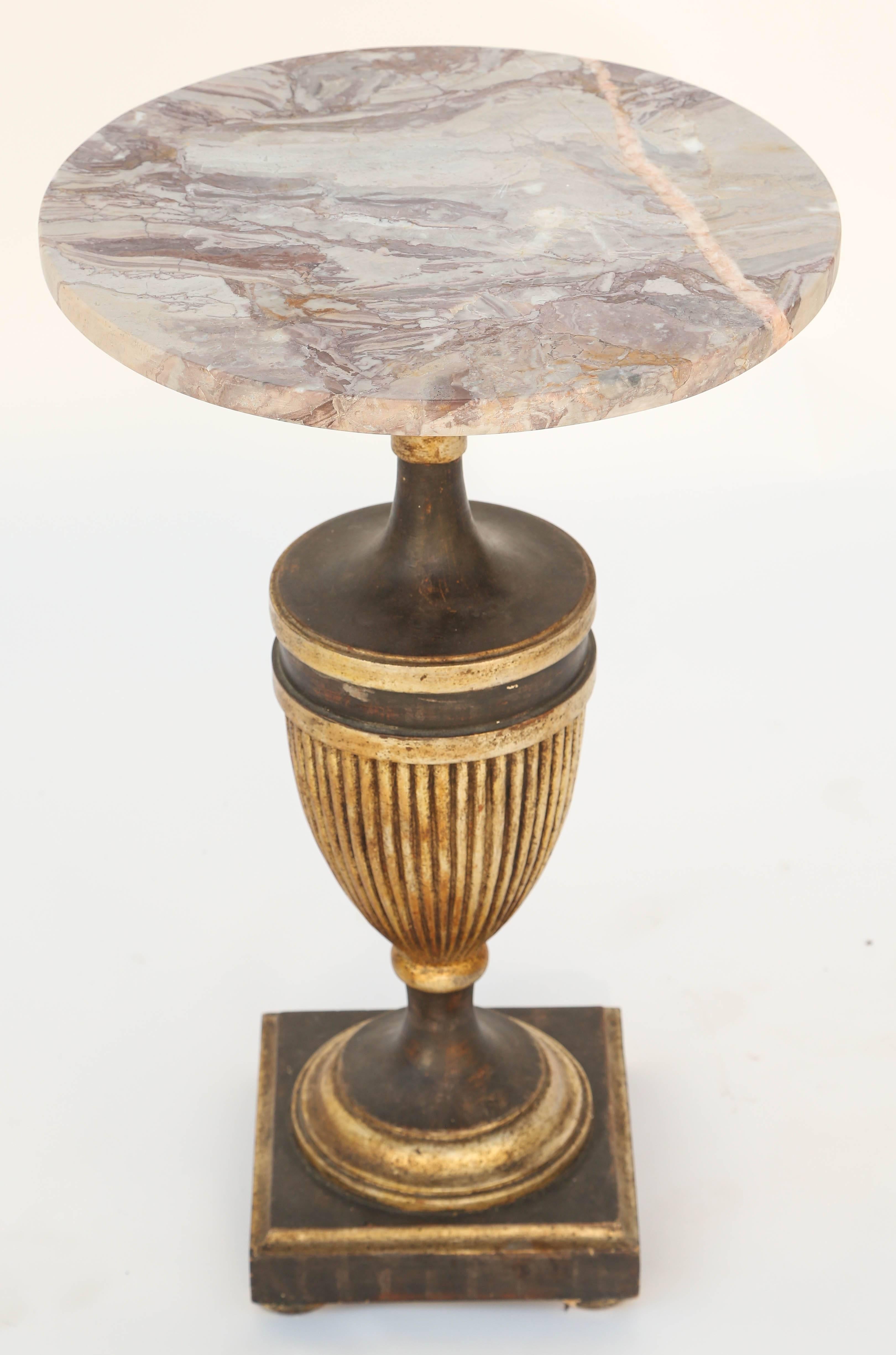 Side table, having a round top of rouge marble, on painted and parcel silver gilt pedestal base, carved in an urn form with fluted body, on round foot, set upon a square plinth base.

Stock ID: D9416
