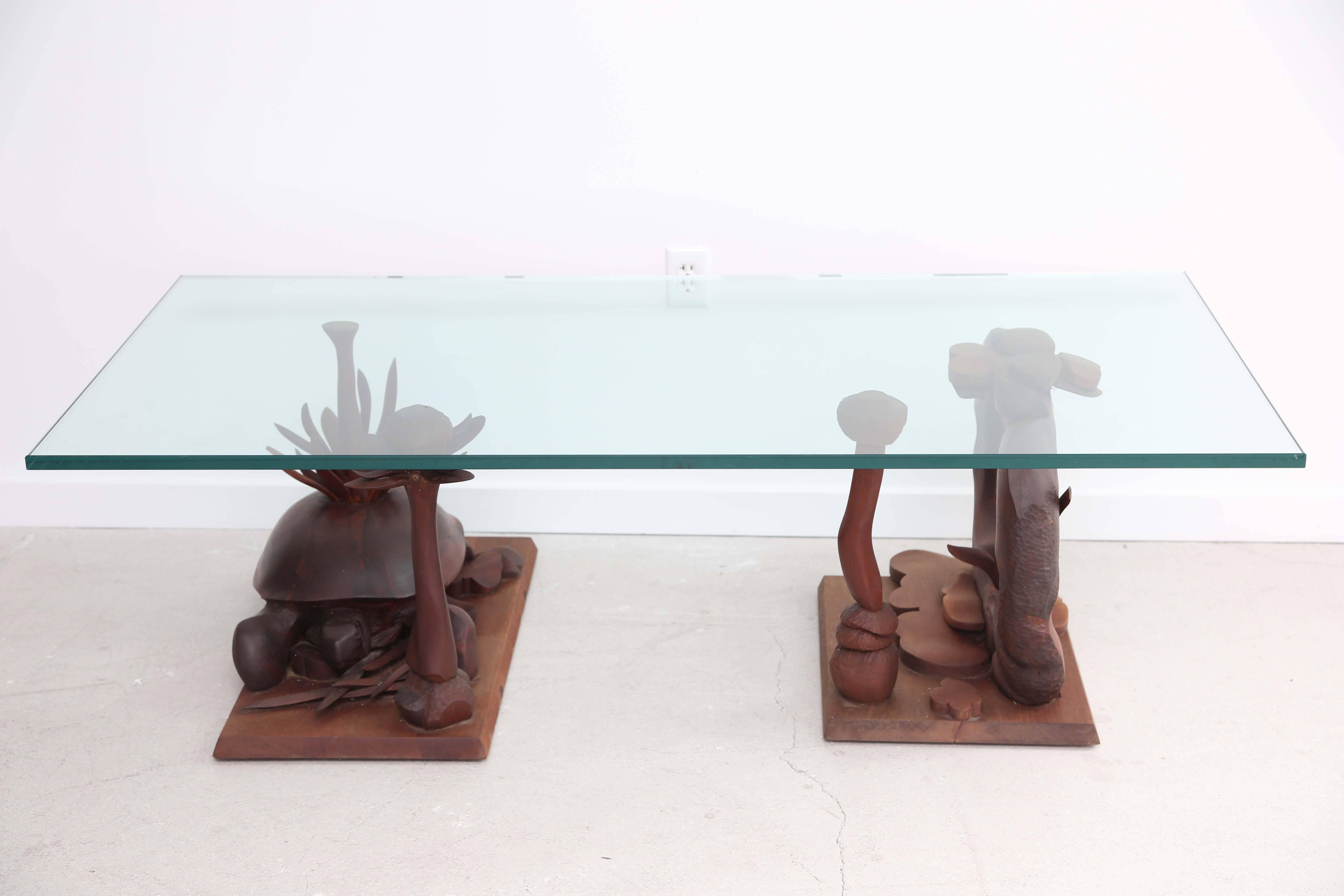 Organic and sculptural hand-carved table with sprouting tendrils, buds and a tortoise! The table is artist made and we have placed a rectangular glass top on it- but the bases may be arranged in various ways and may be two side tables rather than