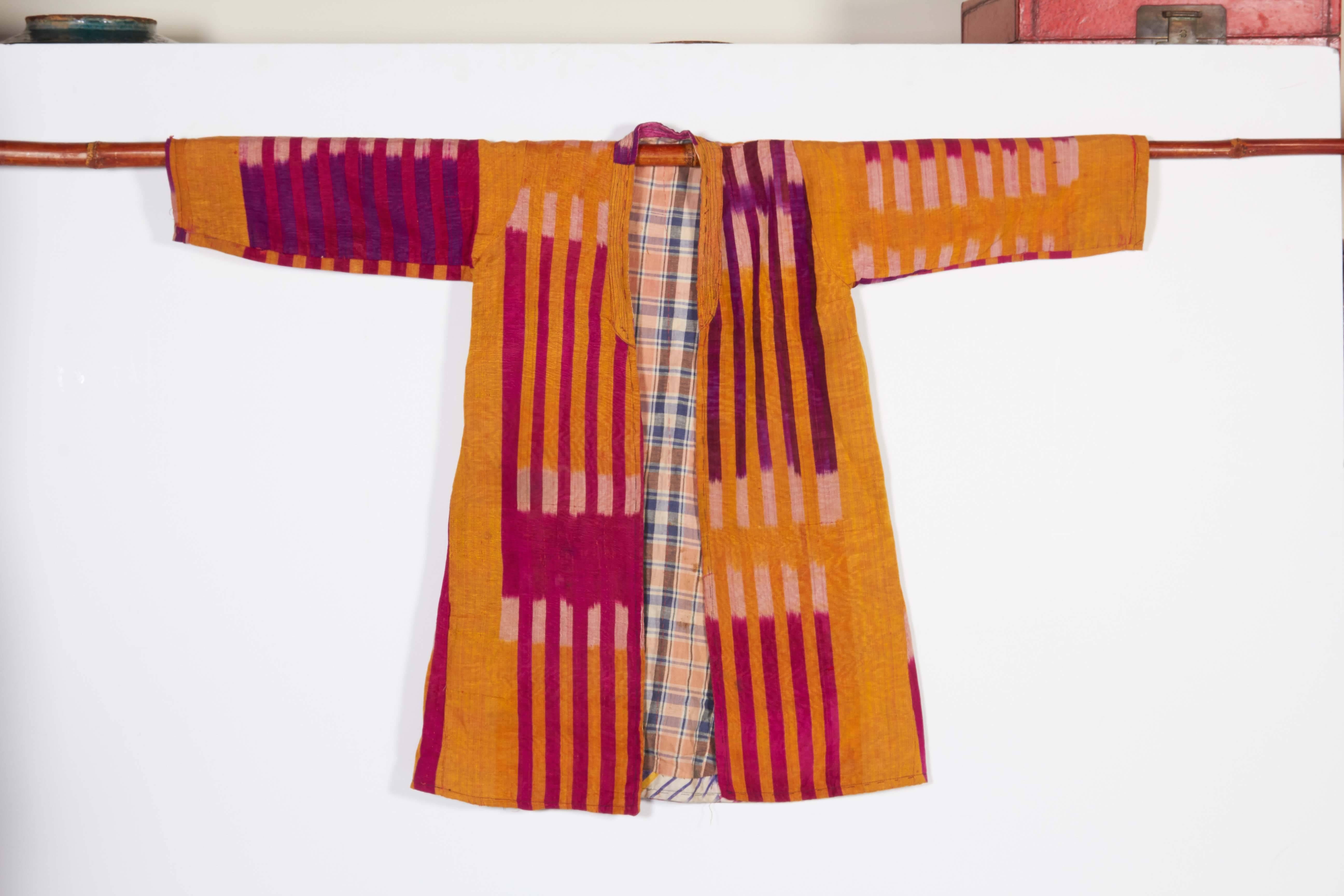 A very colorful and beautifully designed Ikat fabric child's jacket from Uzbekistan, circa 1900. The Ikat dyeing process involves a very high level of skill since first the threads are dyed and then they are weaved into exactly the right section of