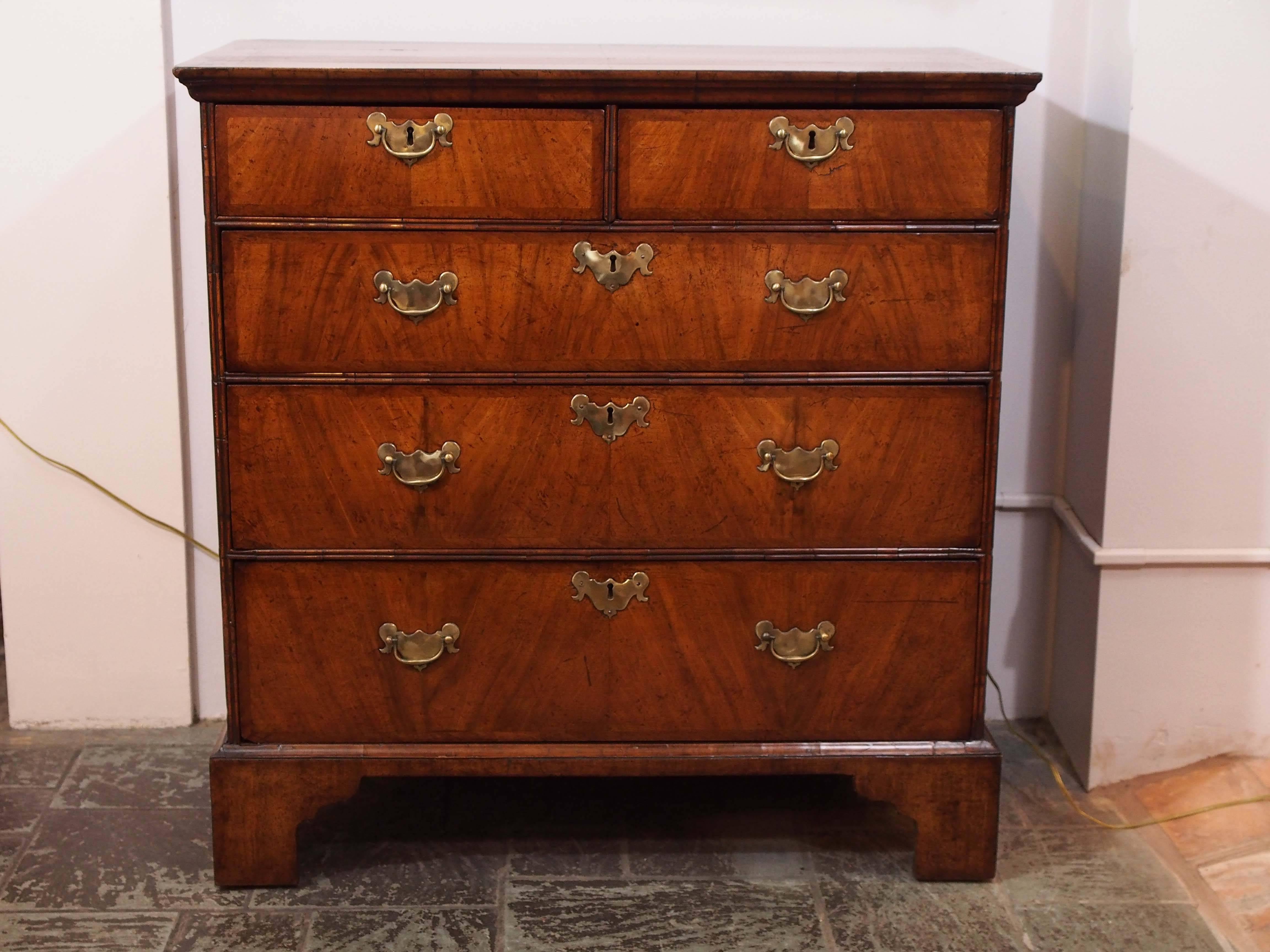 Early 18th century walnut chest of drawers on bracket feet. Oak lined drawers.