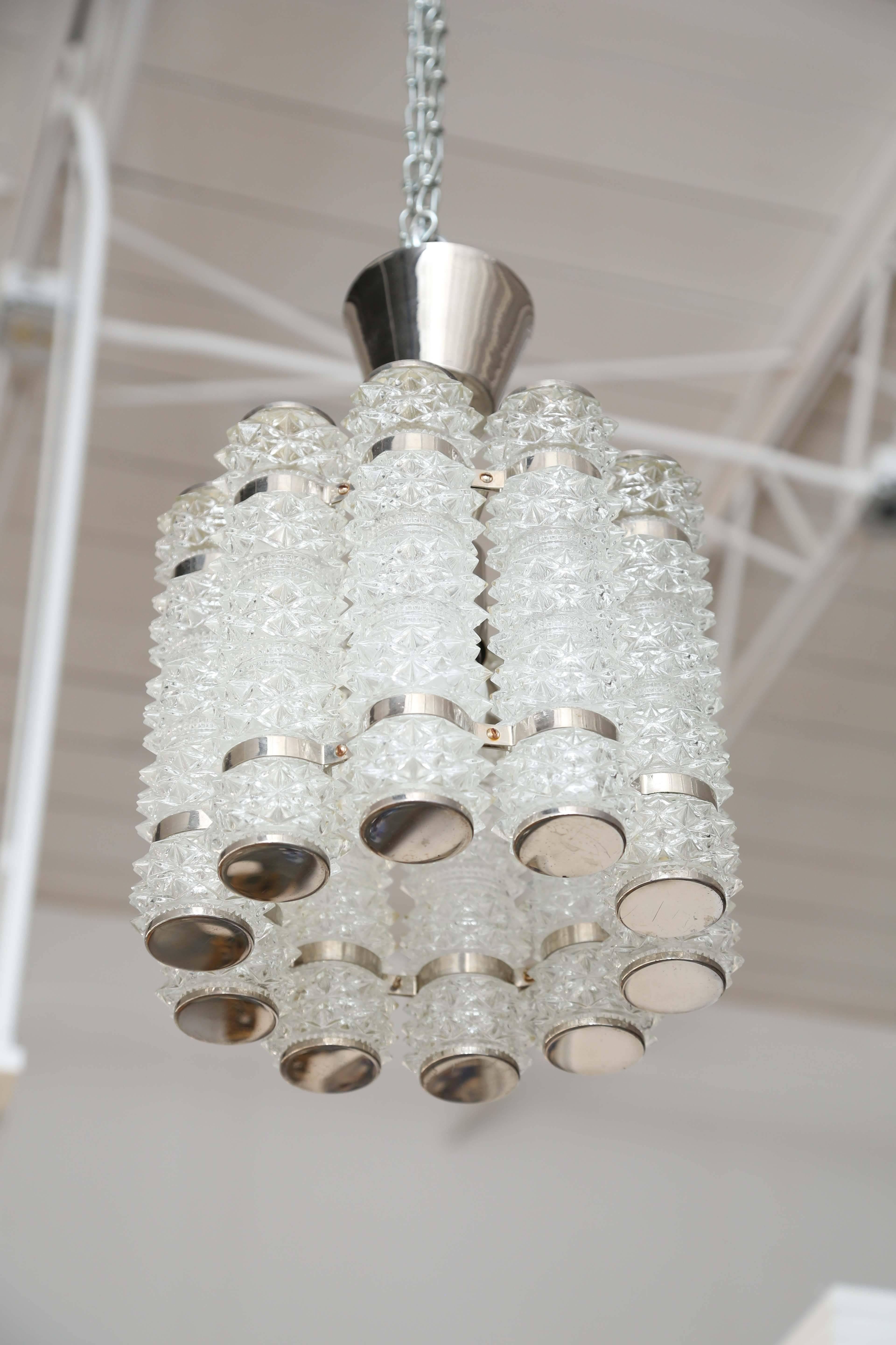 Orrefors chrome and crystal round pendant fixture By Tyringe Crafts.
10 faceted crystal cylinders attached by chrome curved supports and chrome caps top and bottom. Takes one standard Edison light bulb 60 watt max  in centre. 
Has been rewired to