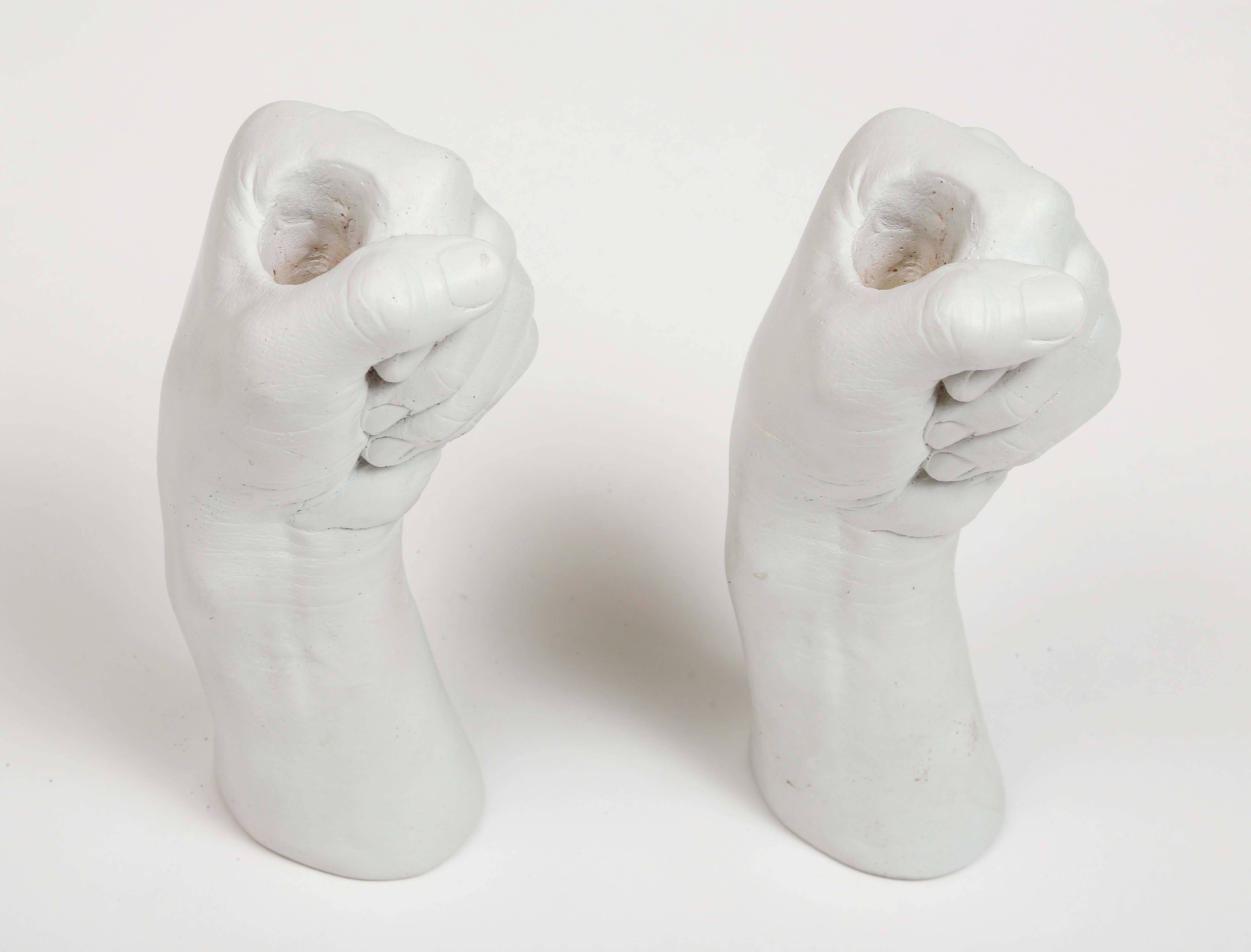 Unusual cast plaster hands by Richard Etts, each fist grasps a candle.