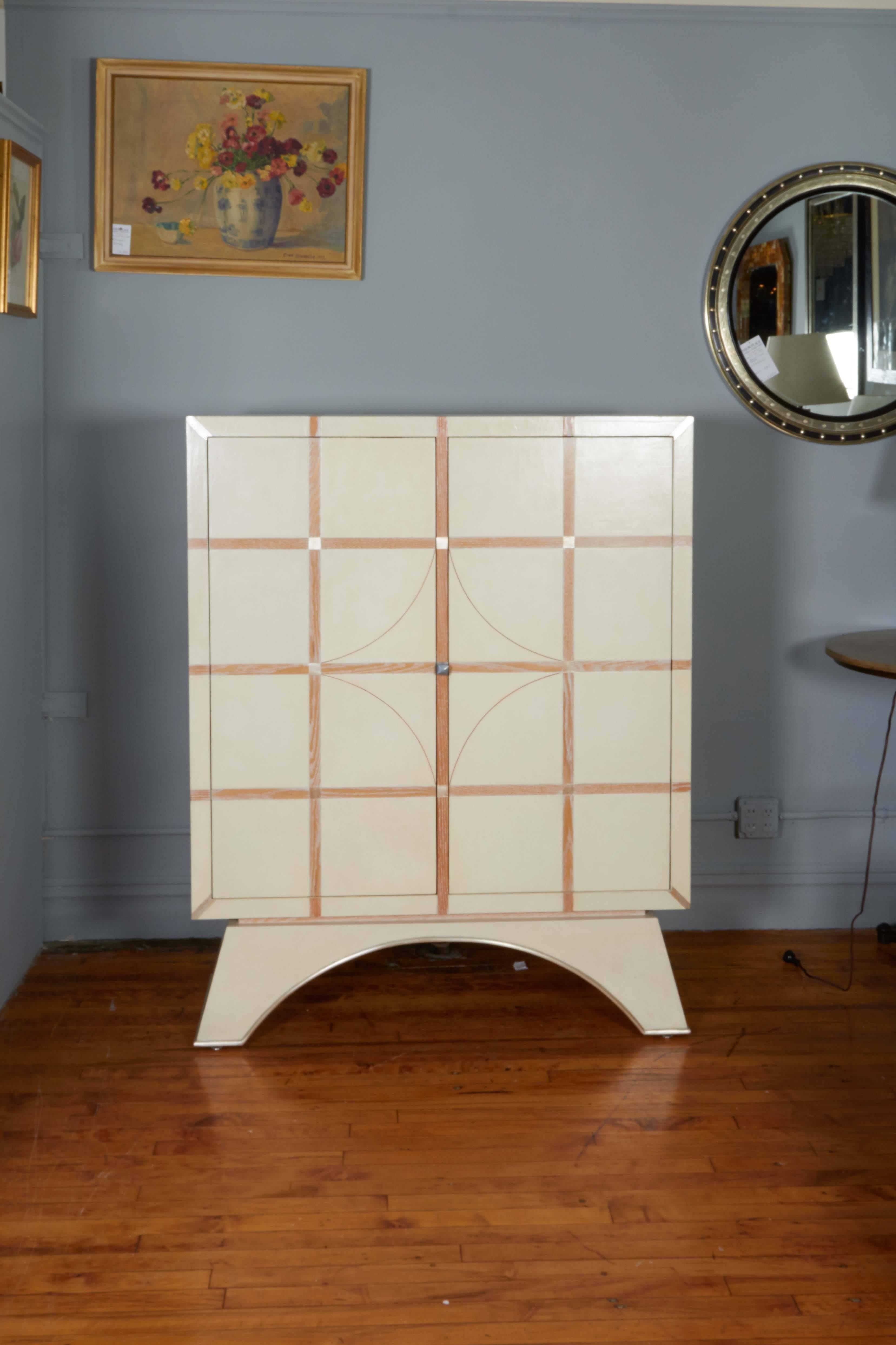 A tall storage cabinet, titled 'Tlamatini' produced by Beni Studio in 2013, crafted of parchment covered oak, with tile pattern, two-doors open to spacious interior with shelving. Includes custom-made locking system with magnetic touch latch doors.
