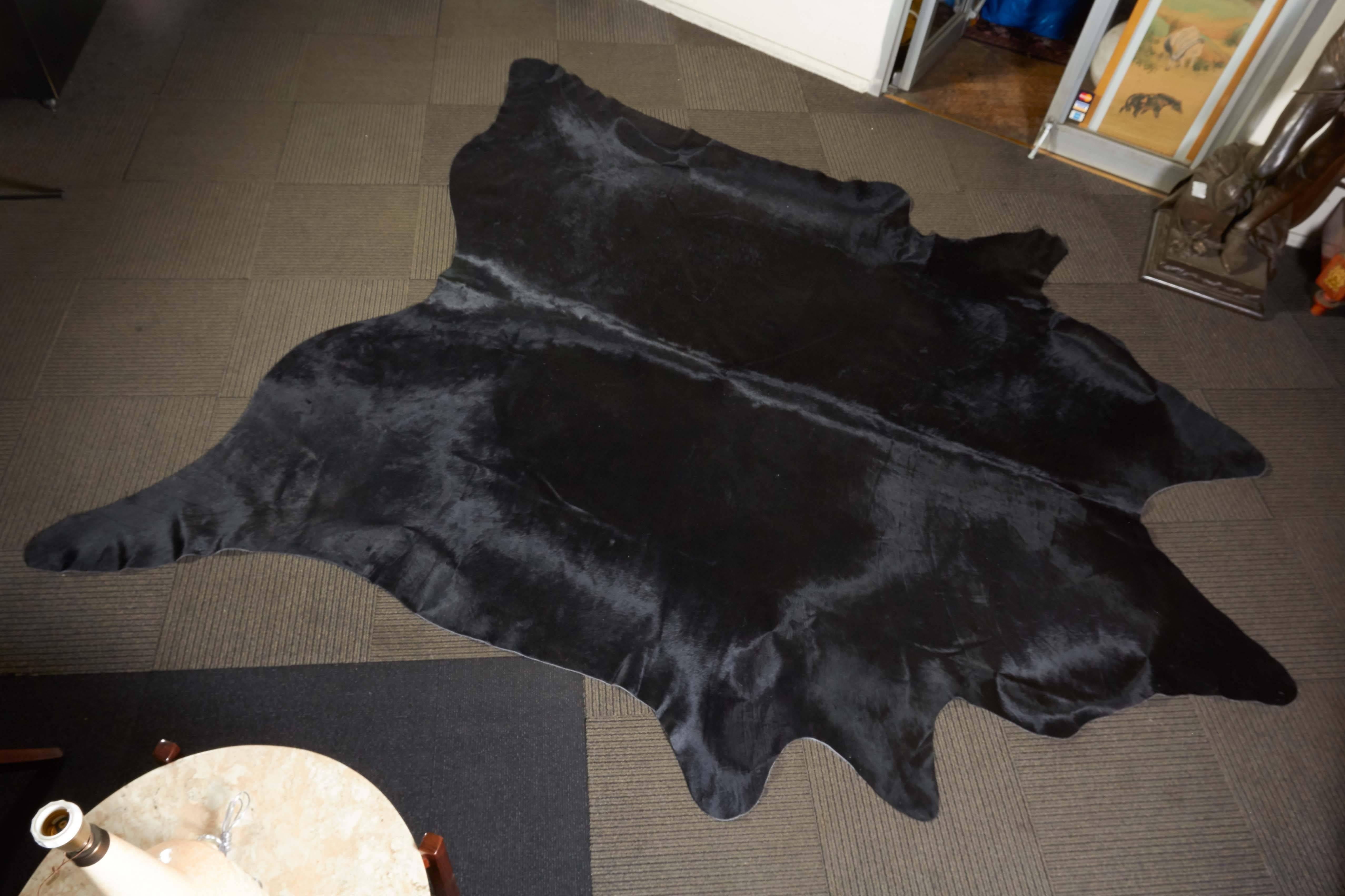 A very large cowhide rug in black. Markings include [Made in Brazil] stamped to underside. Excellent condition.

10871