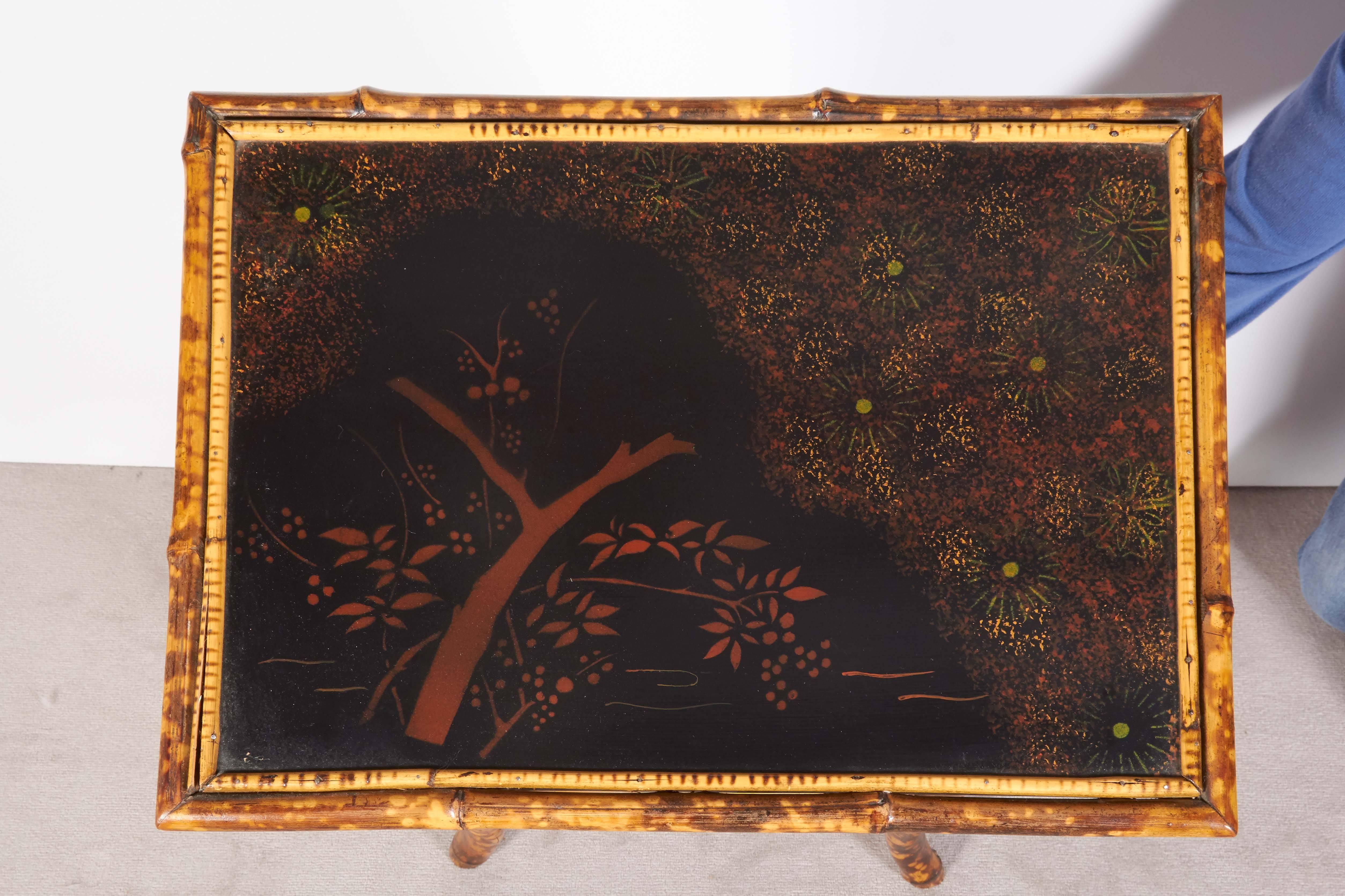 Victorian late 19th century Anglo-Japanese style serving table, the top, lower shelf and four drop leaves in black lacquer with hand-painted floral designs, against tortoiseshell bamboo frame. Very good antique condition, including age appropriate