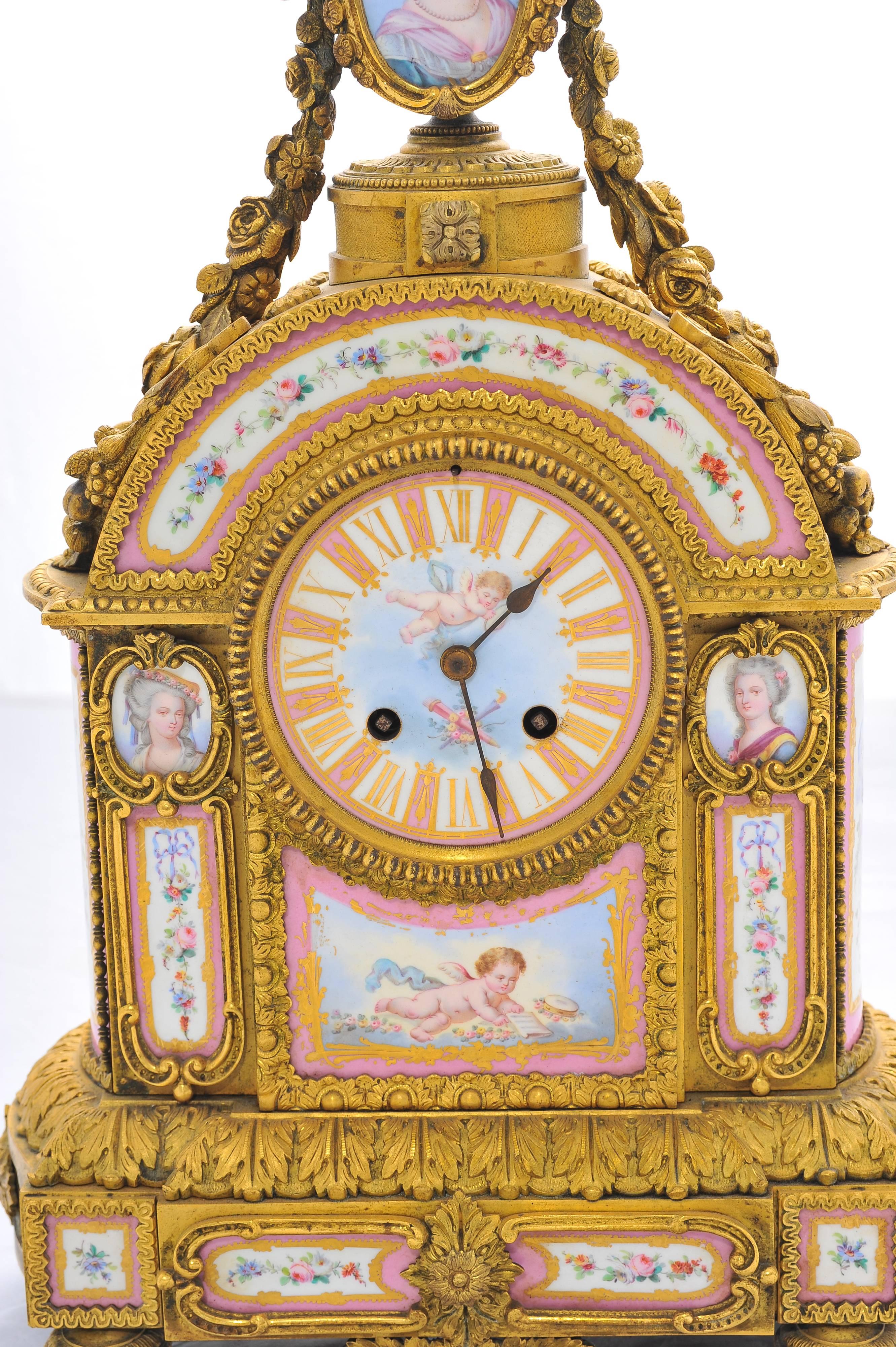 A very pretty 19th century French pink 'Sevres' porcelain and gilded ormolu mantel clock. Having classical foliate and swag decoration surrounding the pink porcelain plaques which depict classical women, cherubs and flowers. The porcelain face with