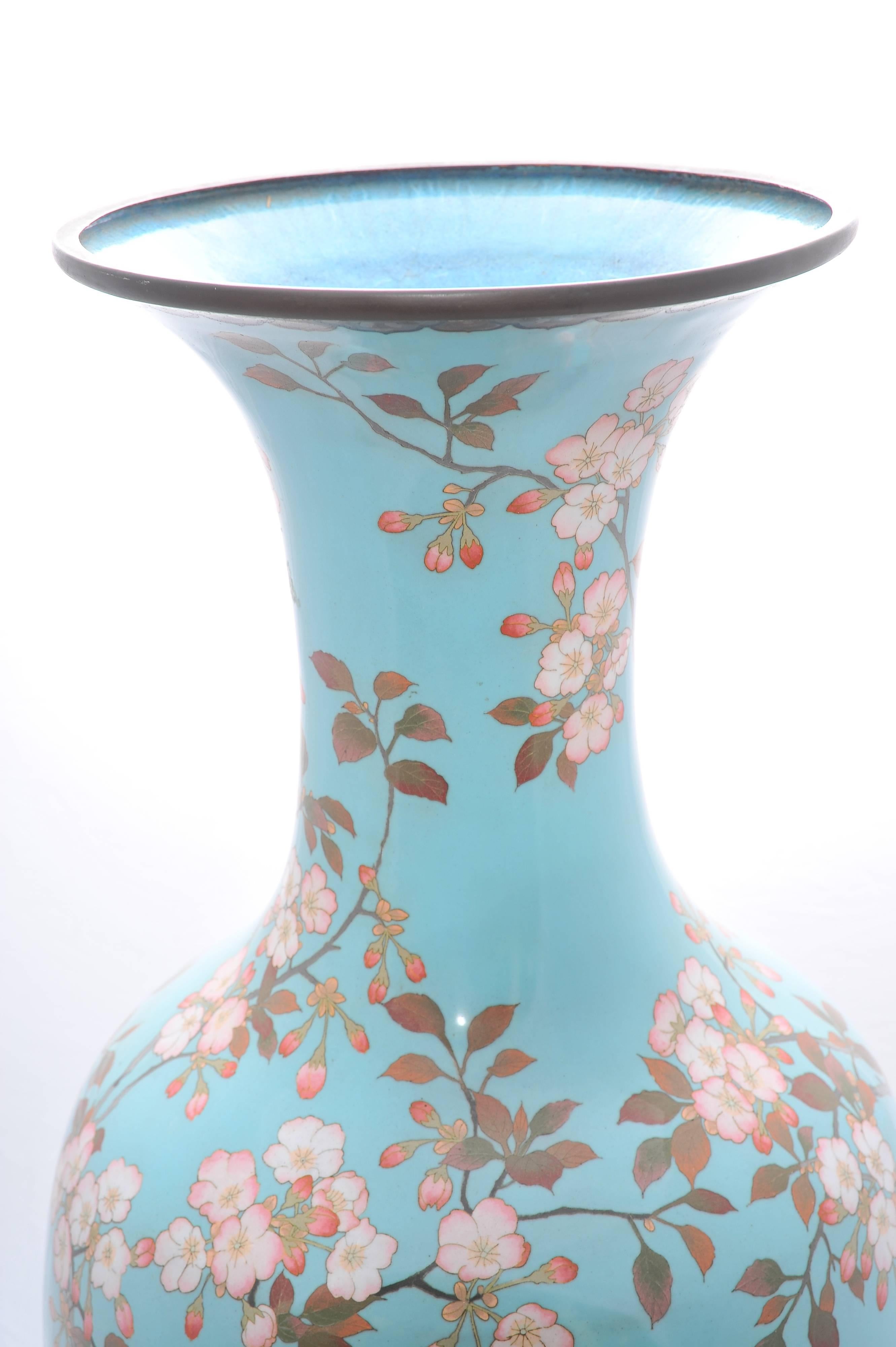 A large good quality Japanese Meiji period (1868-1920) cloisonné vase, having a light blue background, classical flower and foliate decoration with birds perched or flying around.