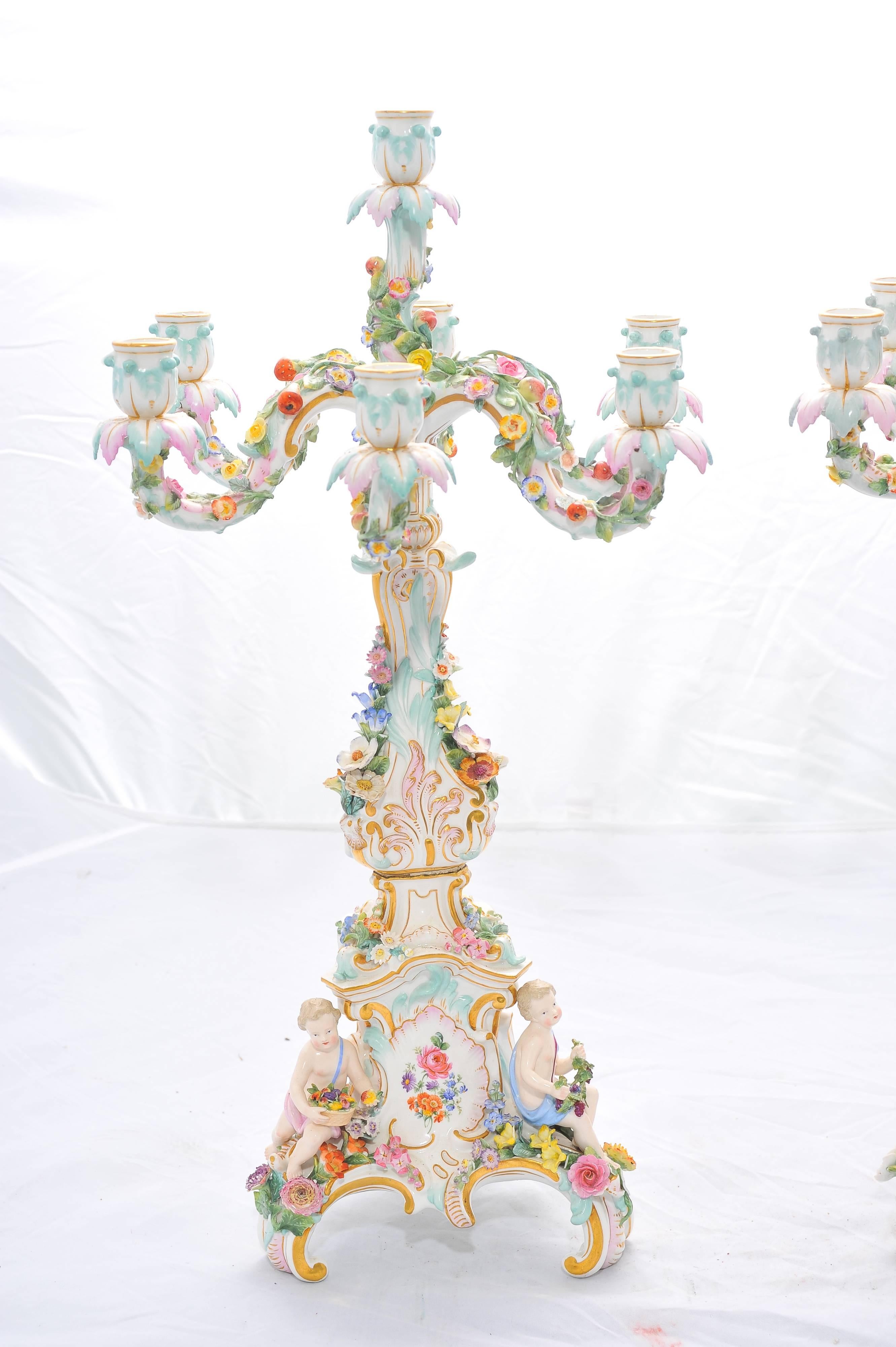 A very good quality and large pair of 19th century Meissen five-branch candelabra. Each having scrolling foliate and floral decoration and supported by 
semi clad putti holding flowers.