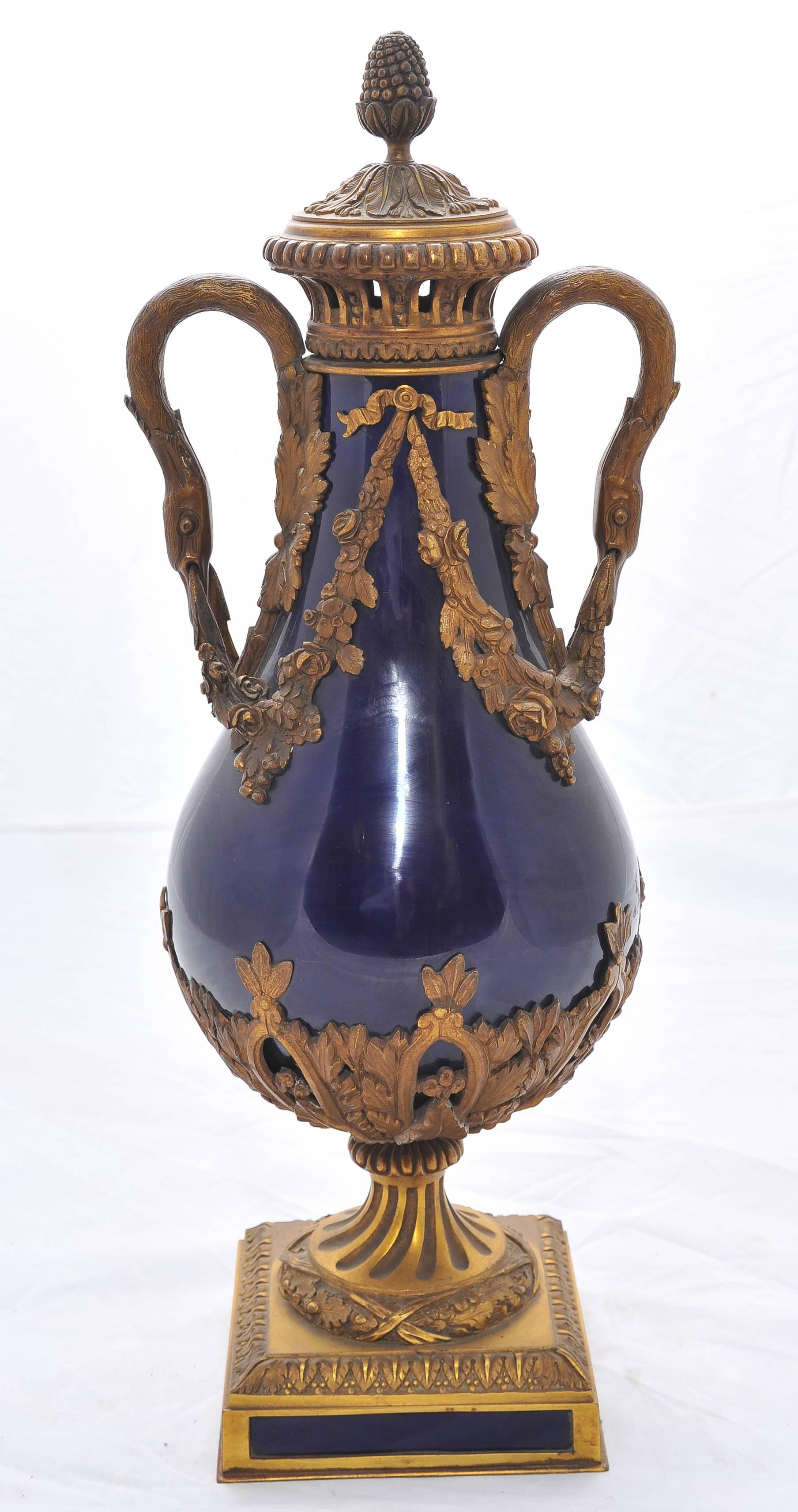 A good quality pair of 19th century Sèvres Royal blue porcelain vases, each with classical gilded ormolu lids, handles and bases.