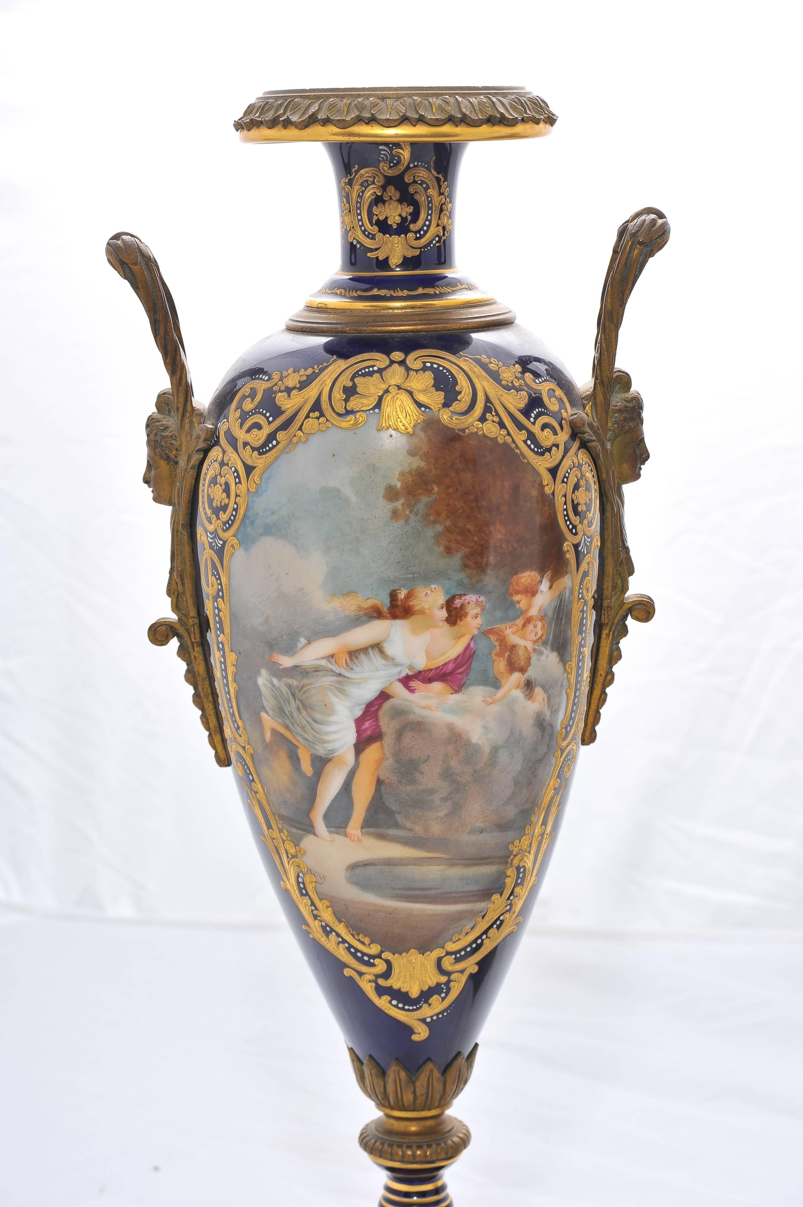 A good quality pair of 19th century 'Sevres' porcelain hand-painted classical vases, depicting romantic scenes to the panels, set in a dark blue background with gilded decoration and raised on ormolu bases.