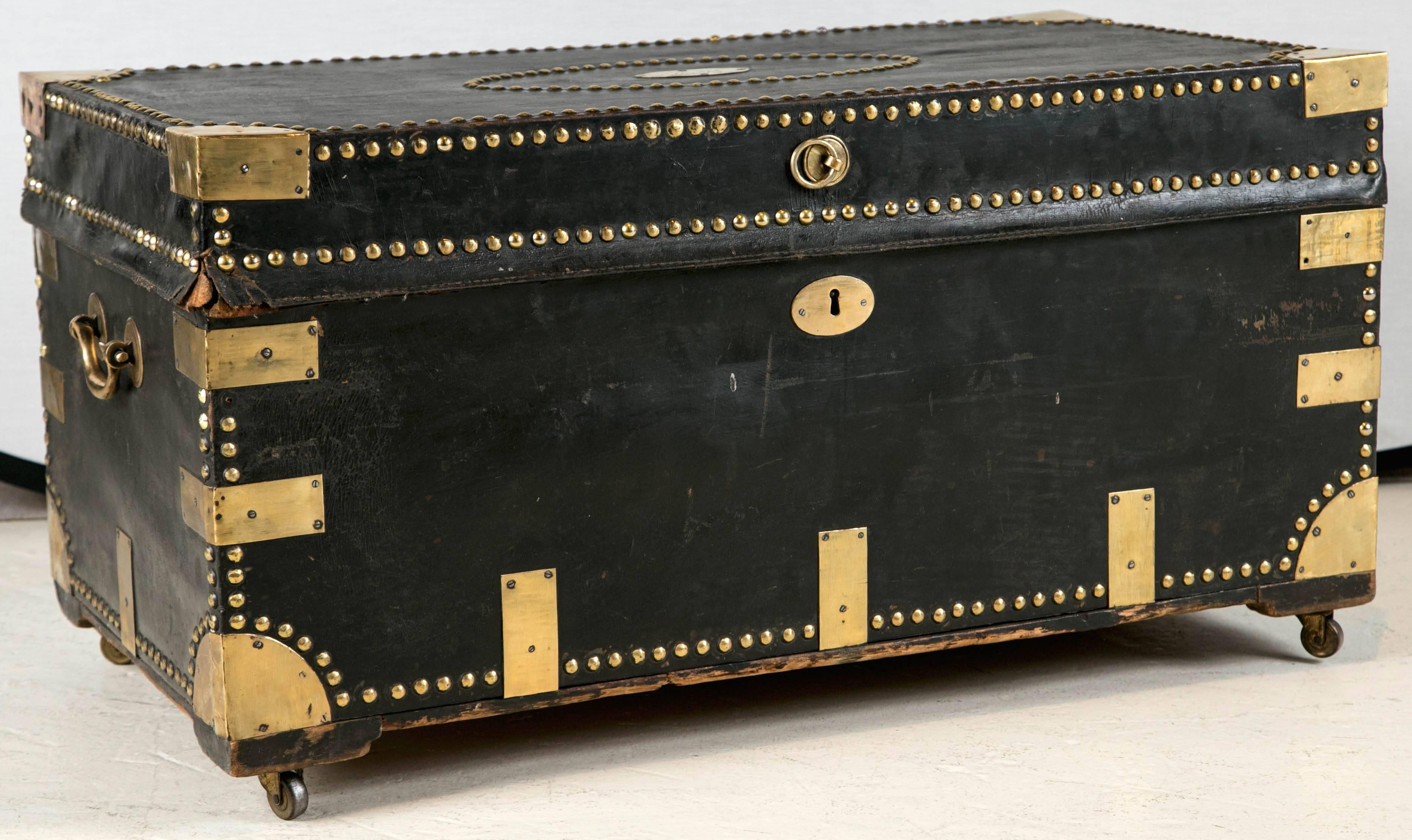 A 19th century brass studded leather military camphor wood trunk or chest mounted on wheels. Paper line interior, circa 1840s
 