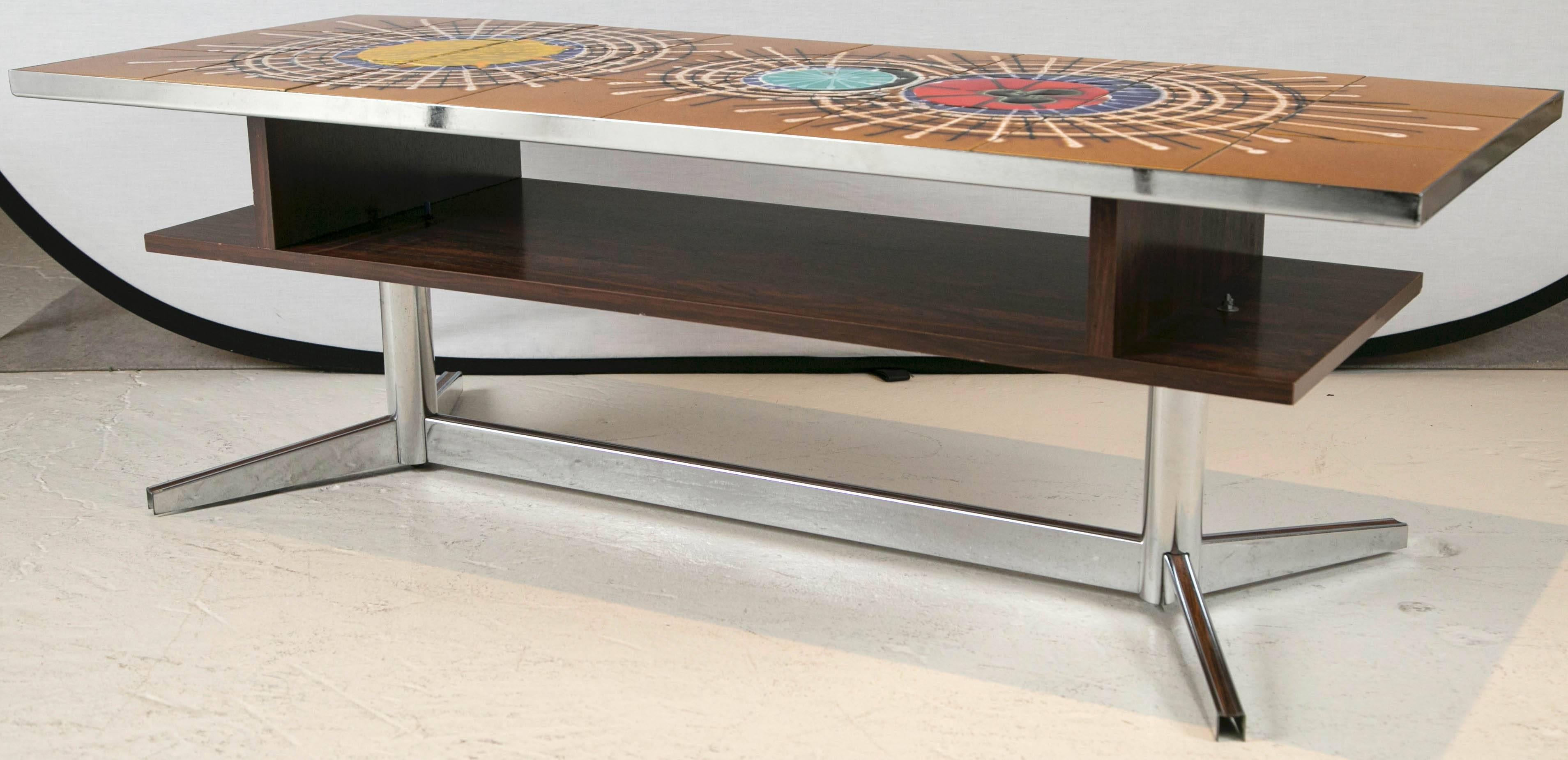 Rosewood, Chrome and abstract glazed tile-top coffee table, circa 1960s.
Wonderful colors and cool abstract designed glaze tile top with rosewood veneered under table shelf and inlaid on chrome legs minor chip on one tile, otherwise excellent