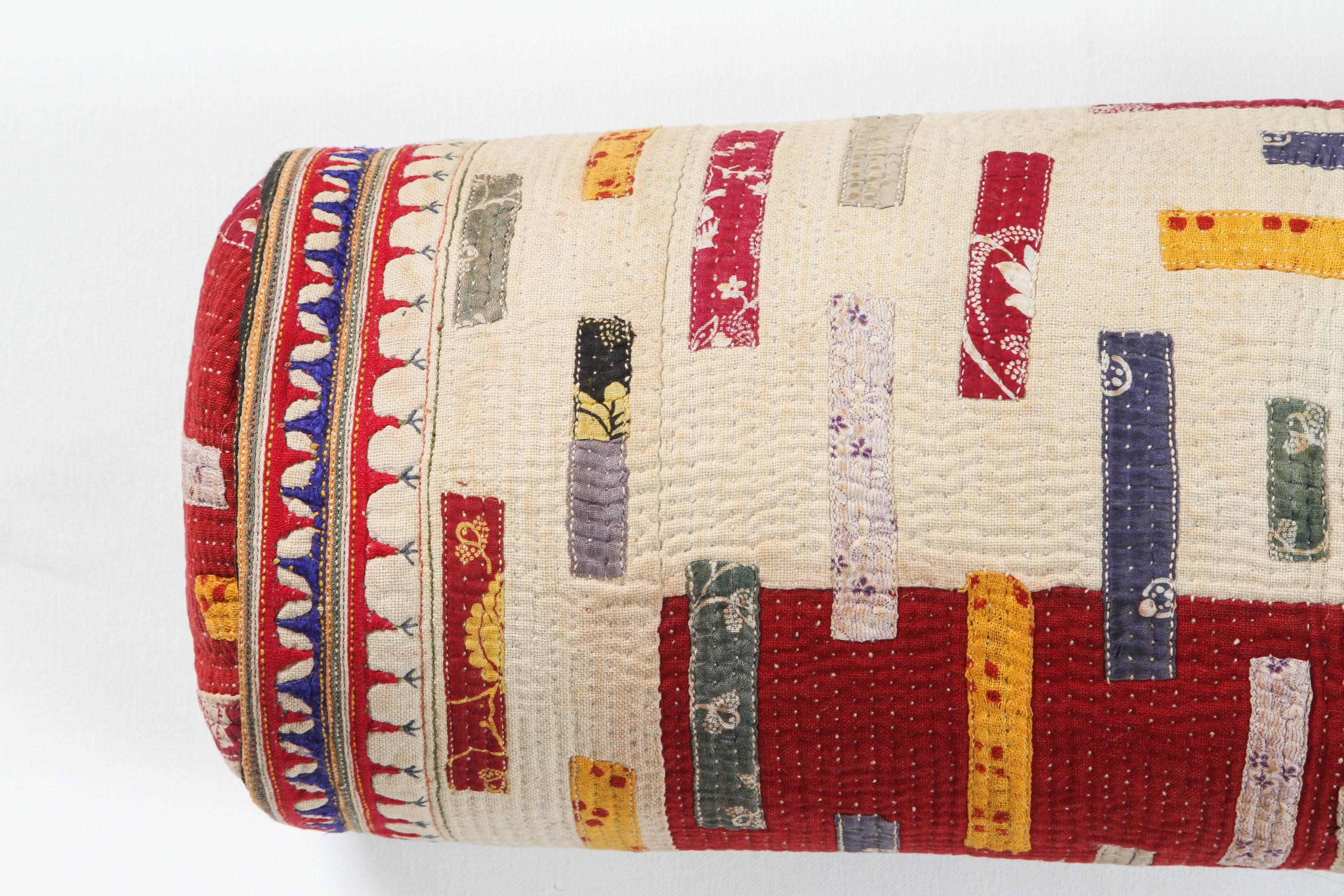 Bolster with zipper. Made from a vintage quilted and appliqued cotton wedding textile from Gujarat, Chaaron Tribal group. Feather and down fill.