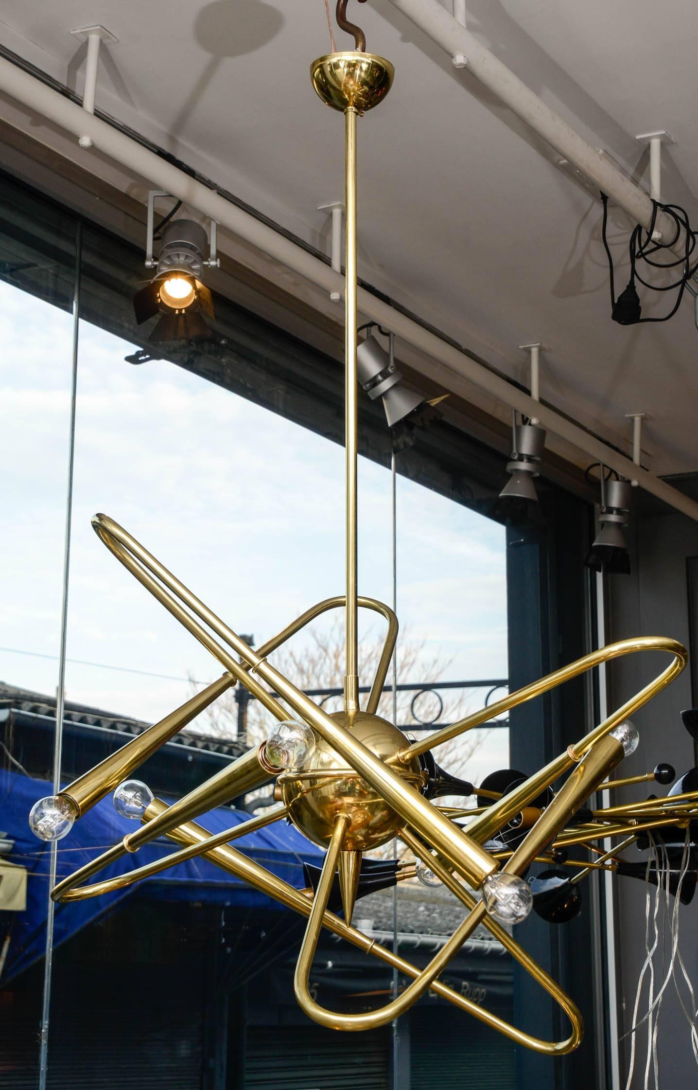 Unusual brass Sputnik chandelier with its long central stem and curved arms giving the illusion of a planet in movement.