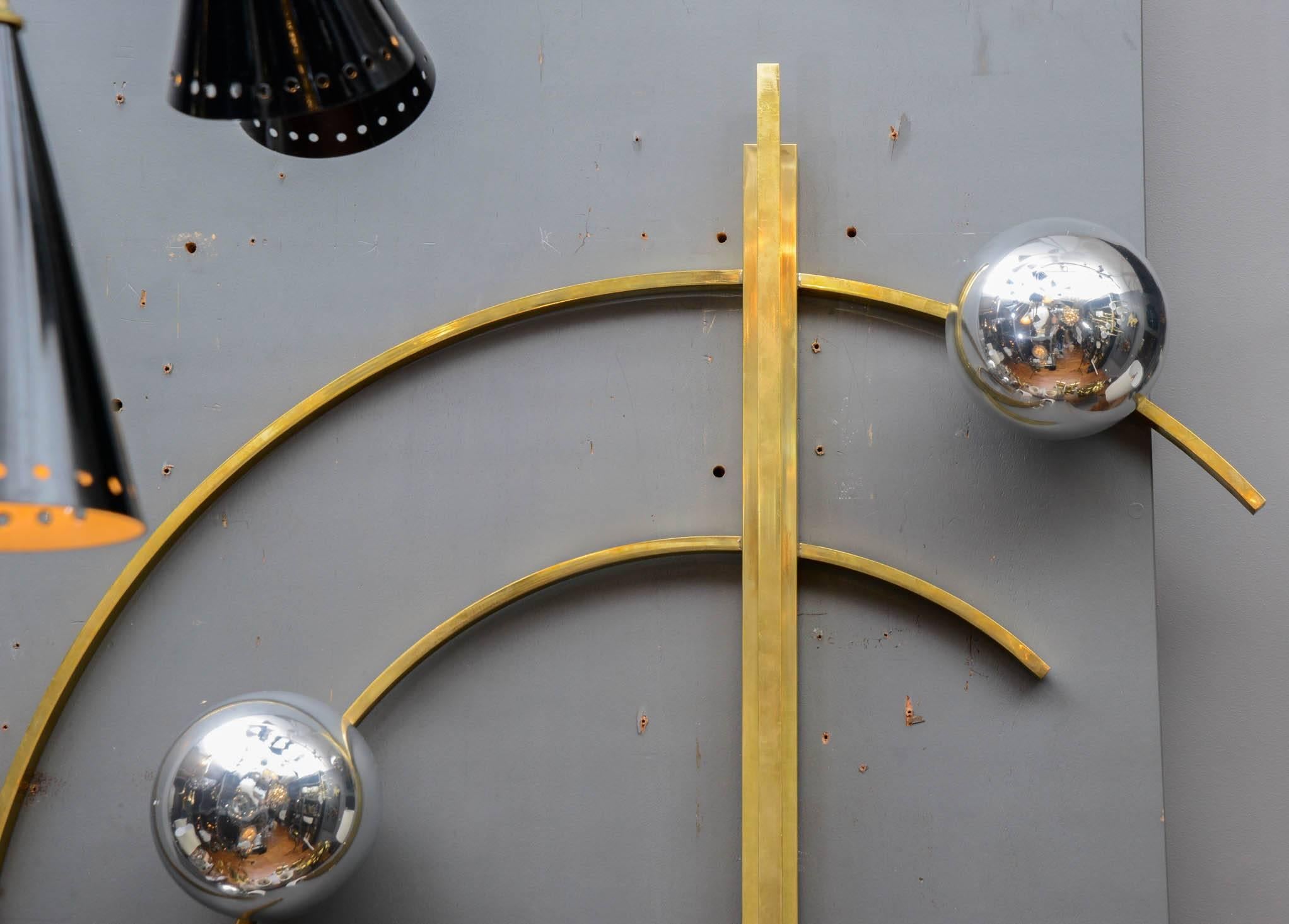 Wall sconces made of brass circular arms and three lights hidden in painted Murano glass globes.