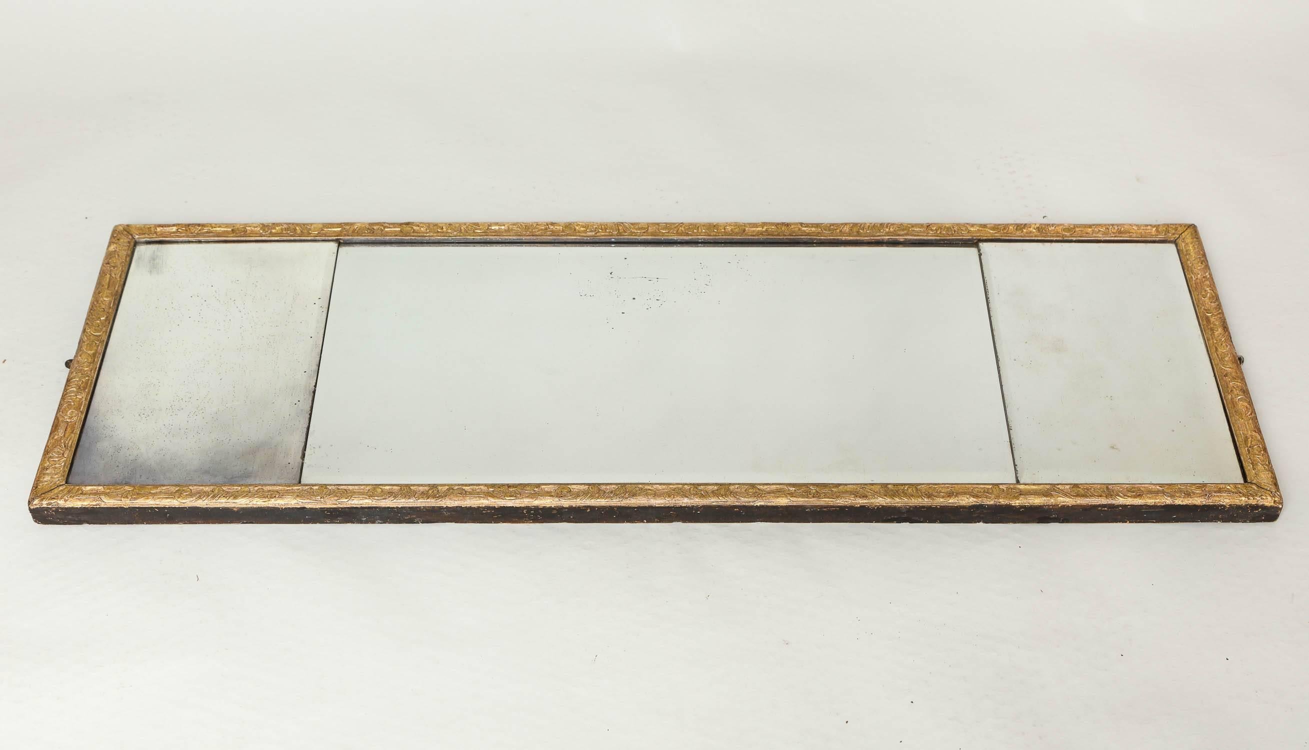 Fine George I carved wood and gilt gesso triple plate overmantel mirror with scroll carved and punched ground border, retaining the three original mercury glass panel with gentle beveled edges and much original gilding.