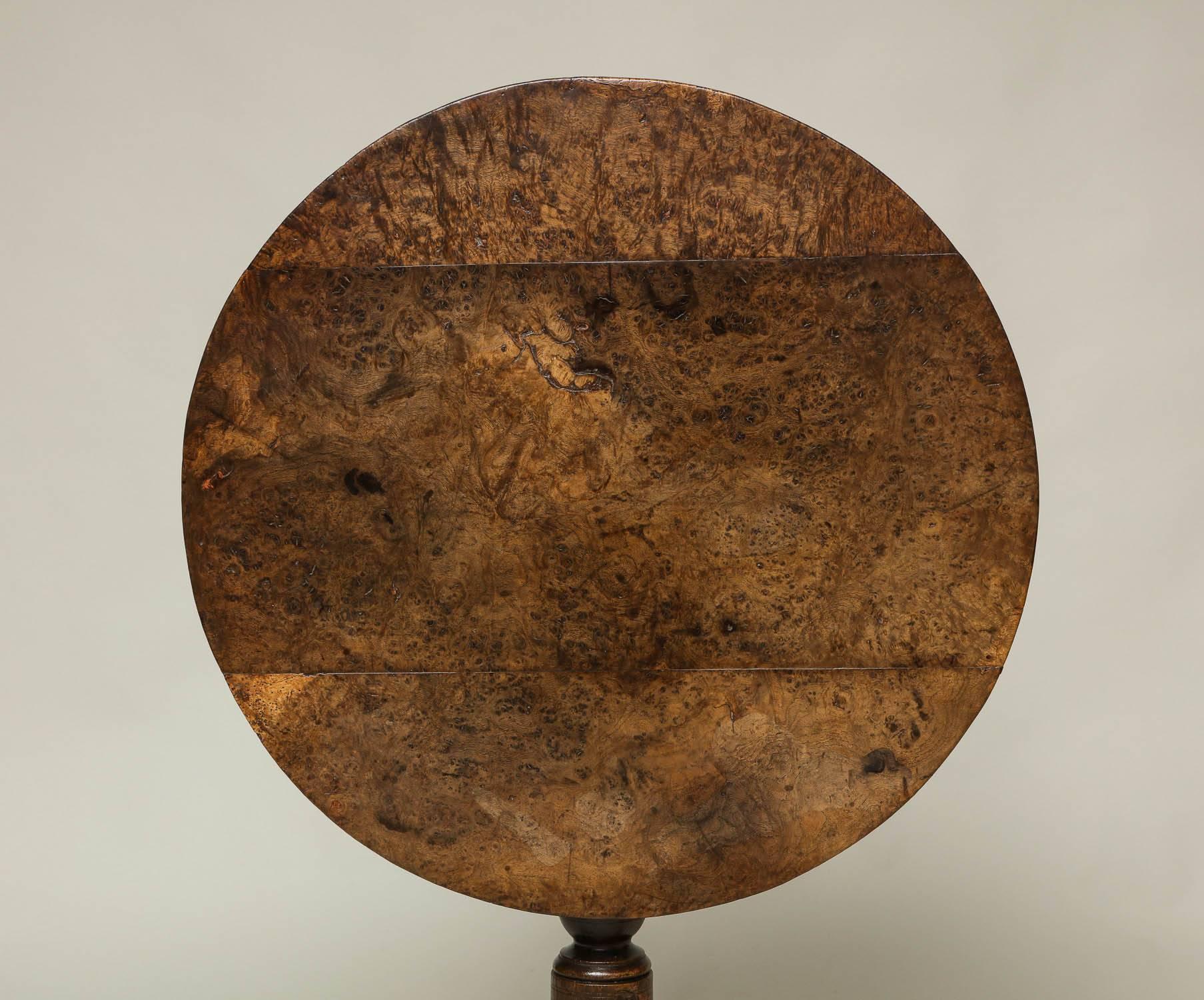 Good George II oak tilt-top table with amazing solid burr top over turned shaft supported by simple shaped slipper feet, retaining blacksmith made latch and possessing beautiful patina.