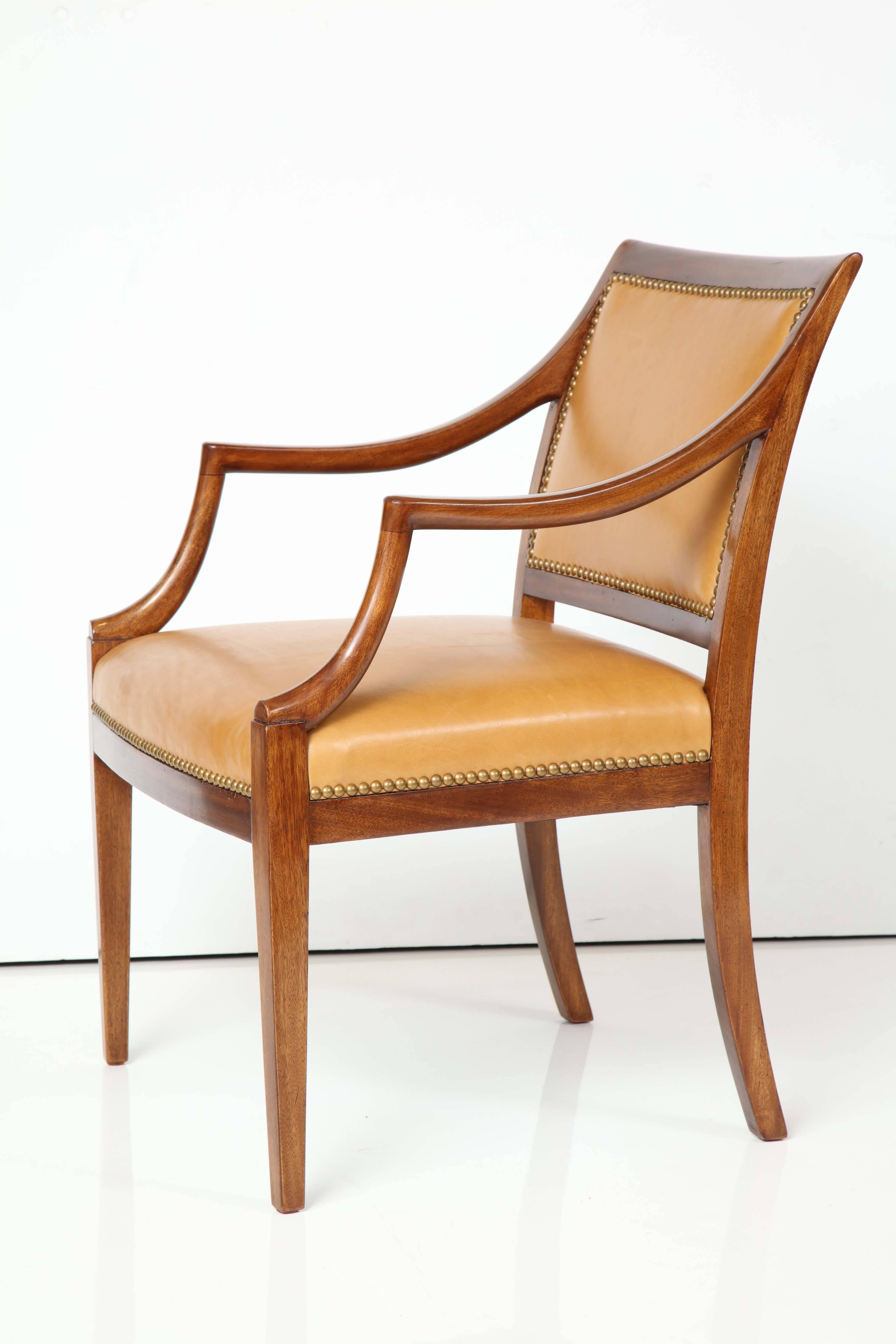 A Frits Henningsen mahogany open armchair with leather seat and back finished with French nailheads, circa 1940s, a rich mahogany frame with downswept armrests raised on square tapered legs. New leather upholstery.