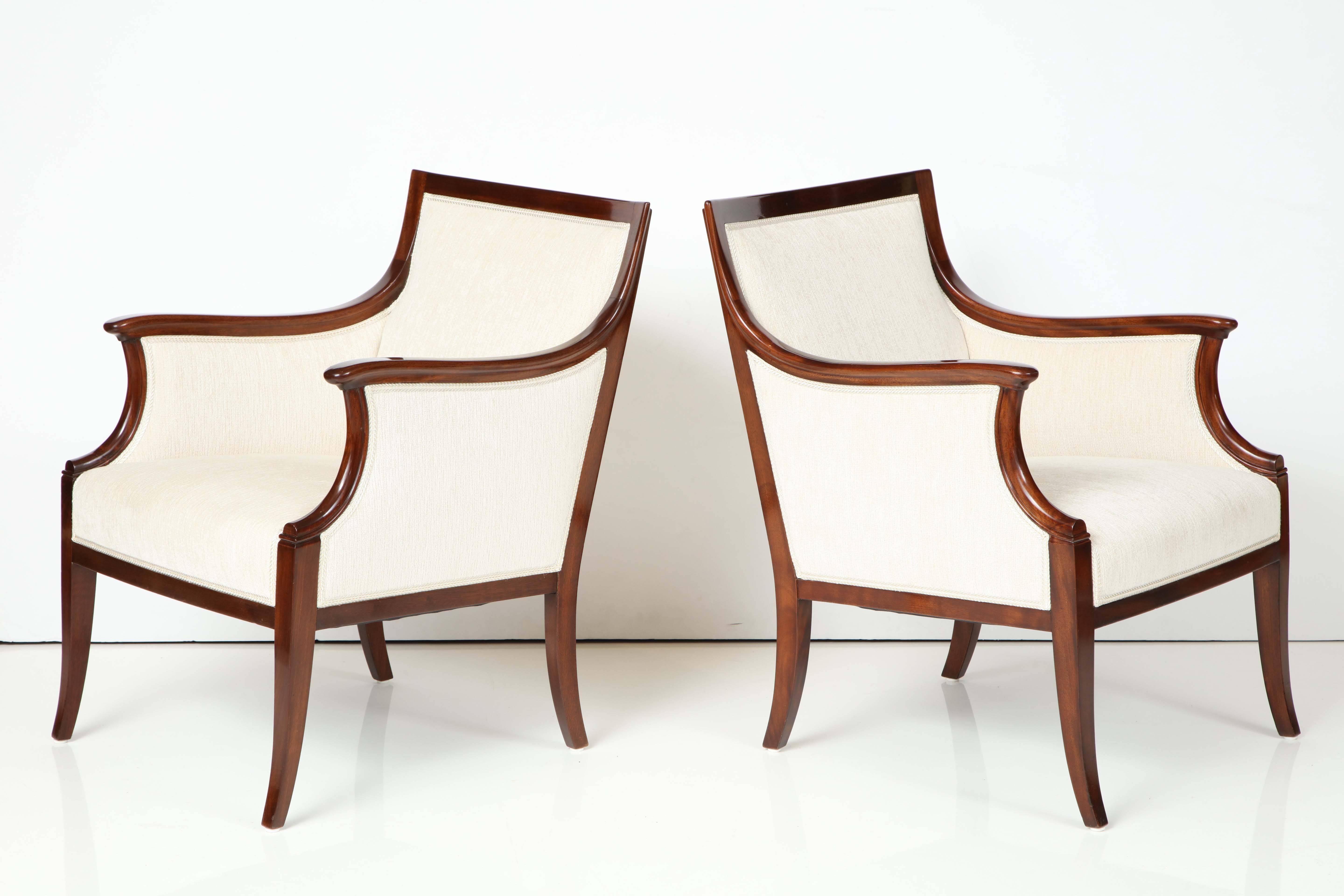 A pair of Danish rich mahogany armchairs by Frits Henningsen, circa 1940, with a slightly curved rectangular backrest, downswept armrests on scrolled supports raised on sabre legs.

Fully restored and re-French polished. New wool upholstery.