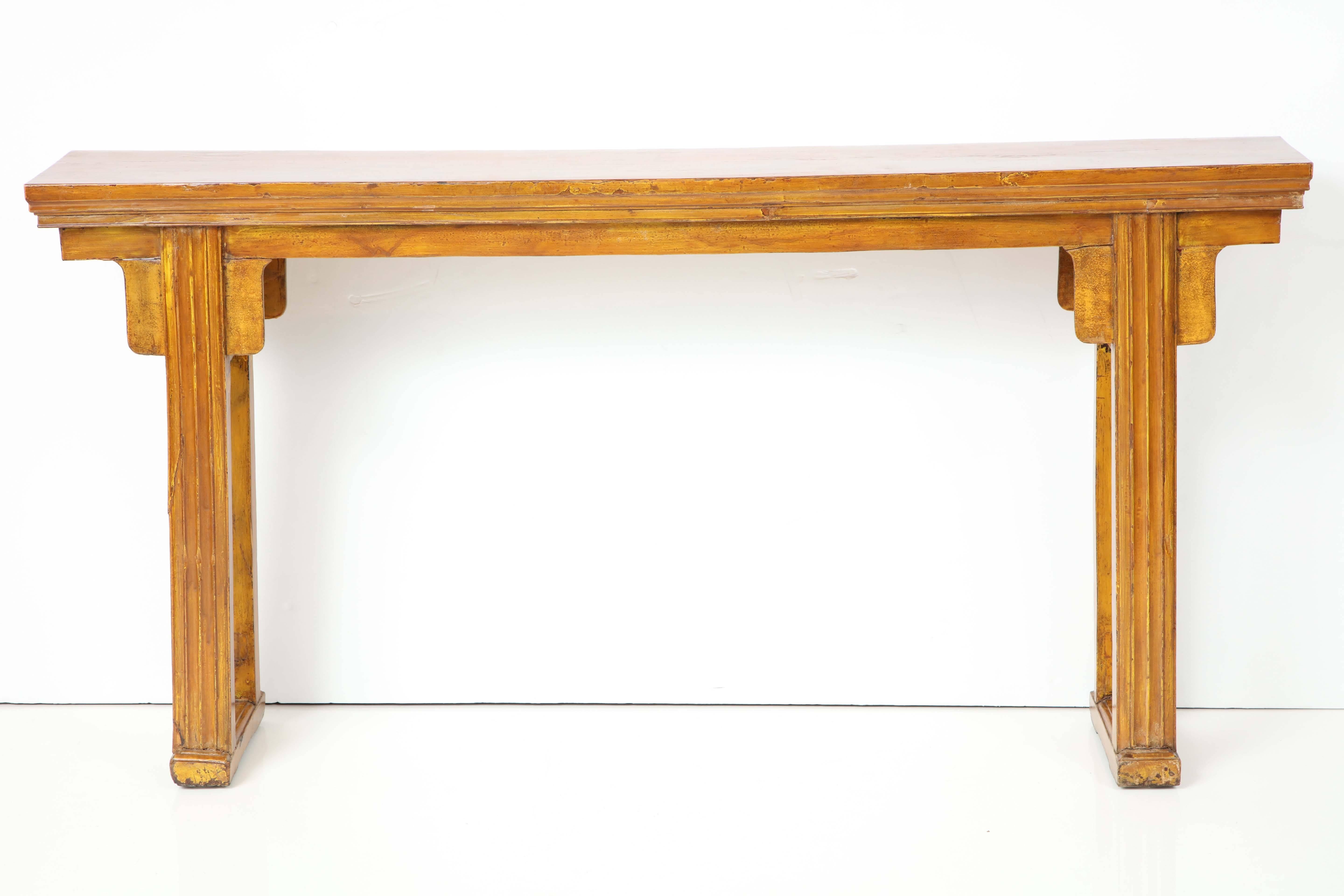 A Chinese yellow lacquered console, late 19th century, with a rectangular top raised on straight channeled supports and joined by a cross support base. Old lacquer finish with a new clear over lacquer. 

This table has very elegant proportions