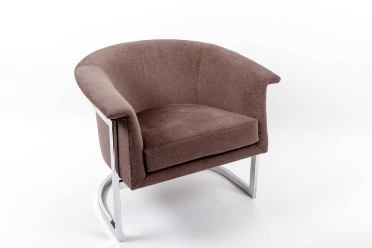 Sleek pair of chromed steel lounge chairs in the style of Milo Baughman. 

Sharp design consists of a curved, chrome-plated steel frame and rounded barrel back. 

The pair has been newly reupholstered in a warm, plush brown fabric; fantastic