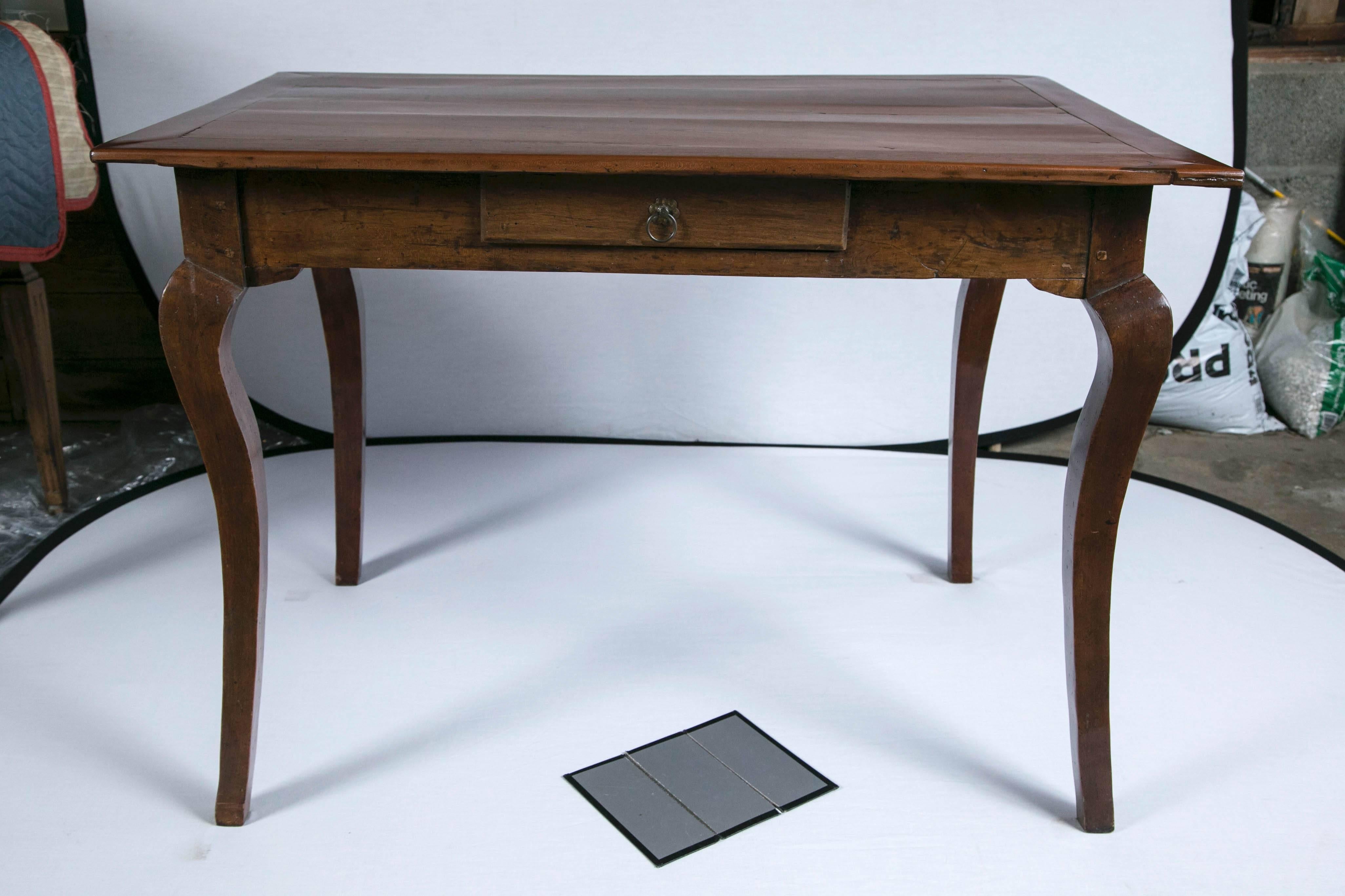 Walnut writing table, 19th century, France. Beautiful aged walnut patina. Curved and tapered cabriole legs. Single drawer with original escutcheon.