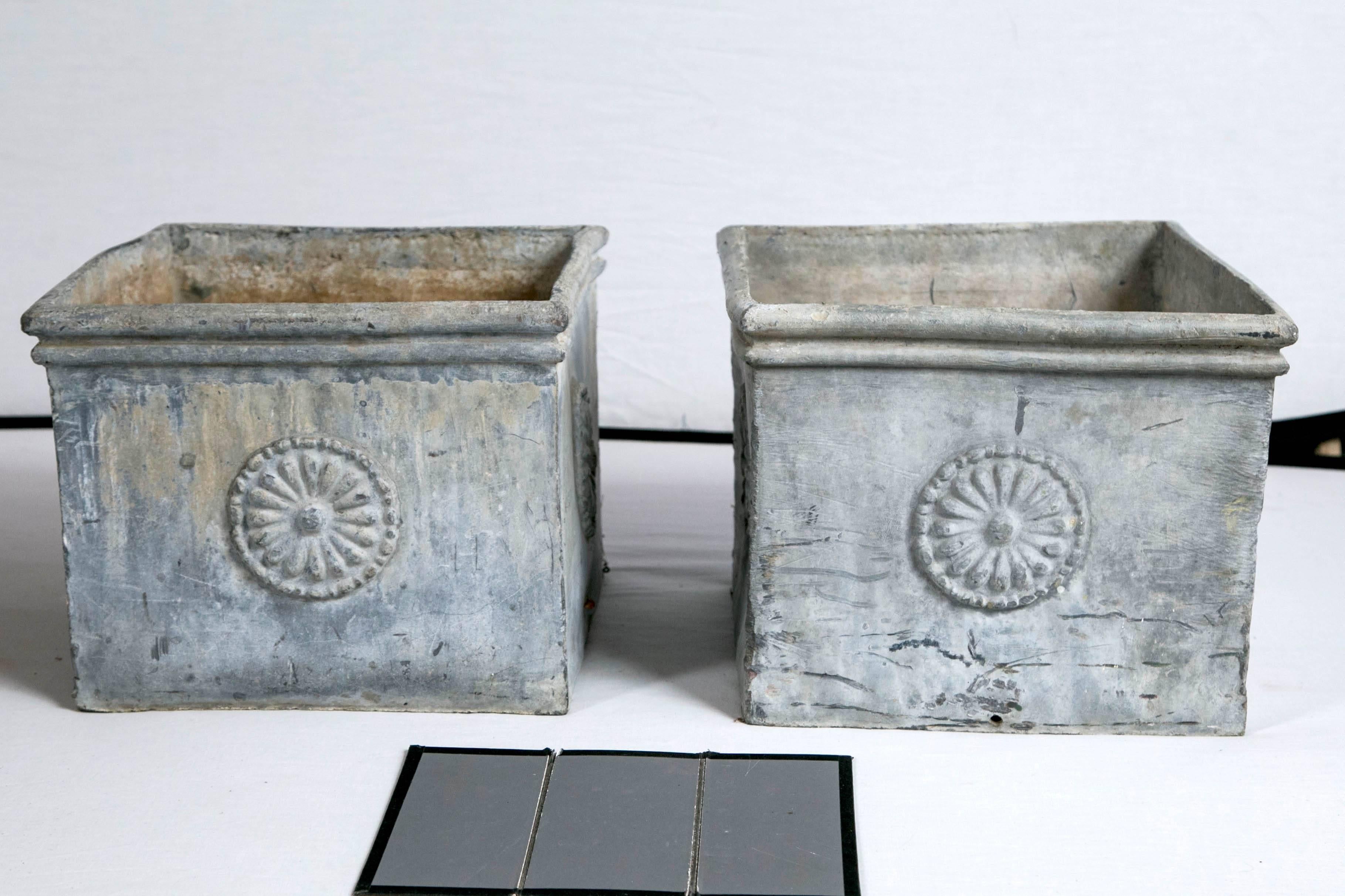 Pair of English lead planters, circa 1900. A wonderful matched pair of lead garden planters with highly detailed medallion decoration. Aged gray patina.