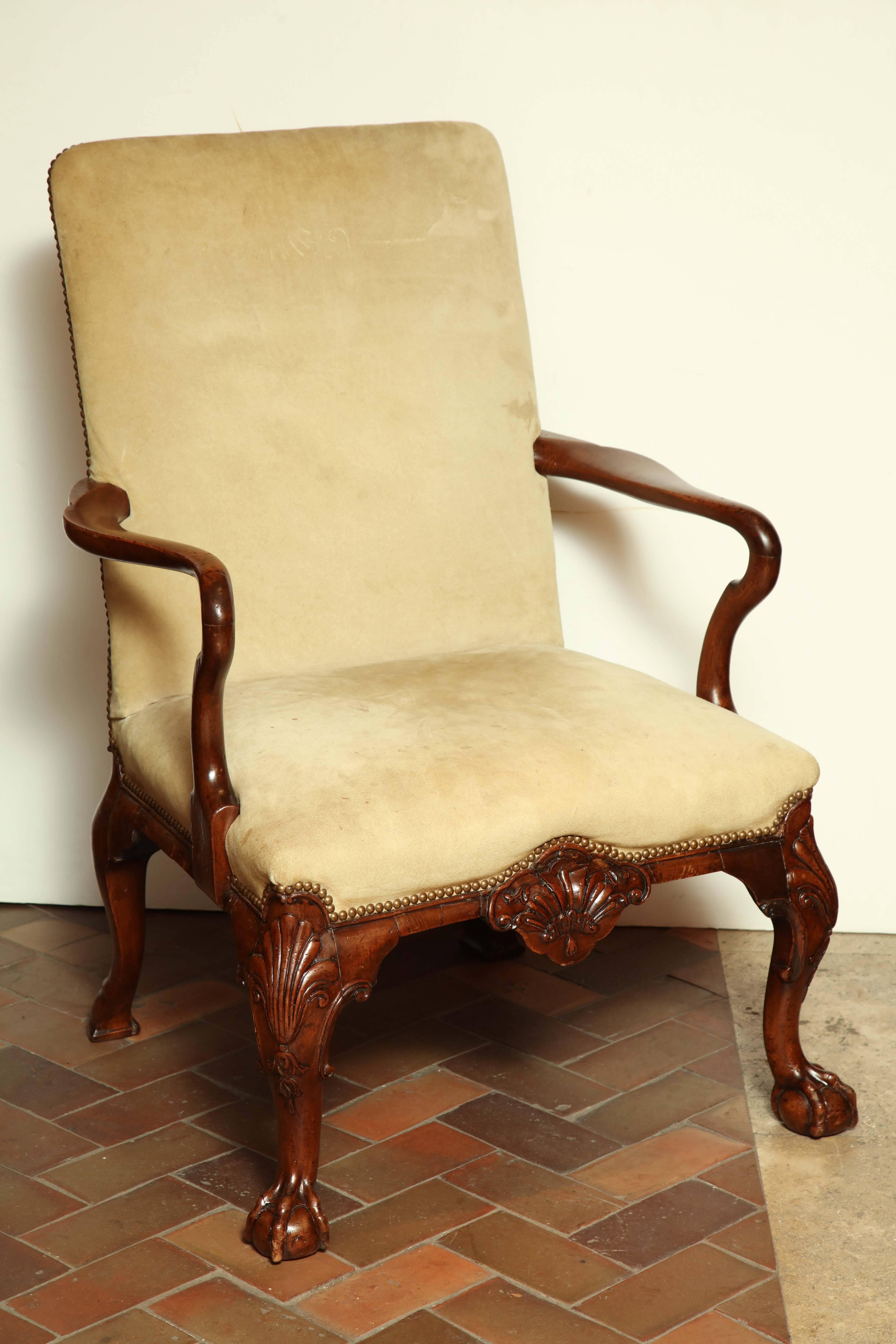 Pair of George II carved walnut library arm chairs with ball and claw feet, shell carved apron and shepherds crook arms.