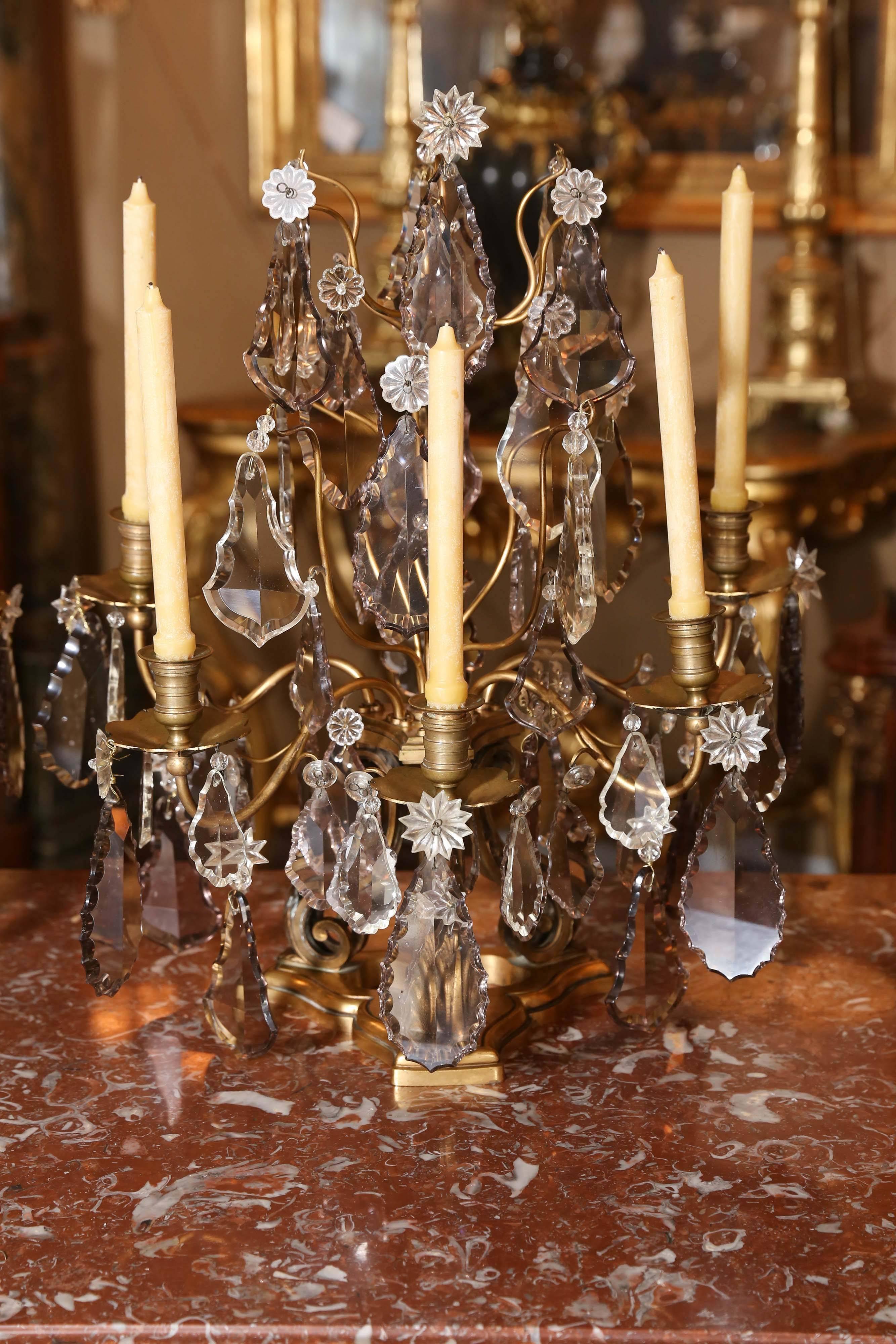 Pair of exquisite bronze and crystal girondles with five candles on each.
French 19th century; the crystal is beautiful without chips and none are missing 
Having a scrolled base and graceful scrolled arms that support the candleholders.
 