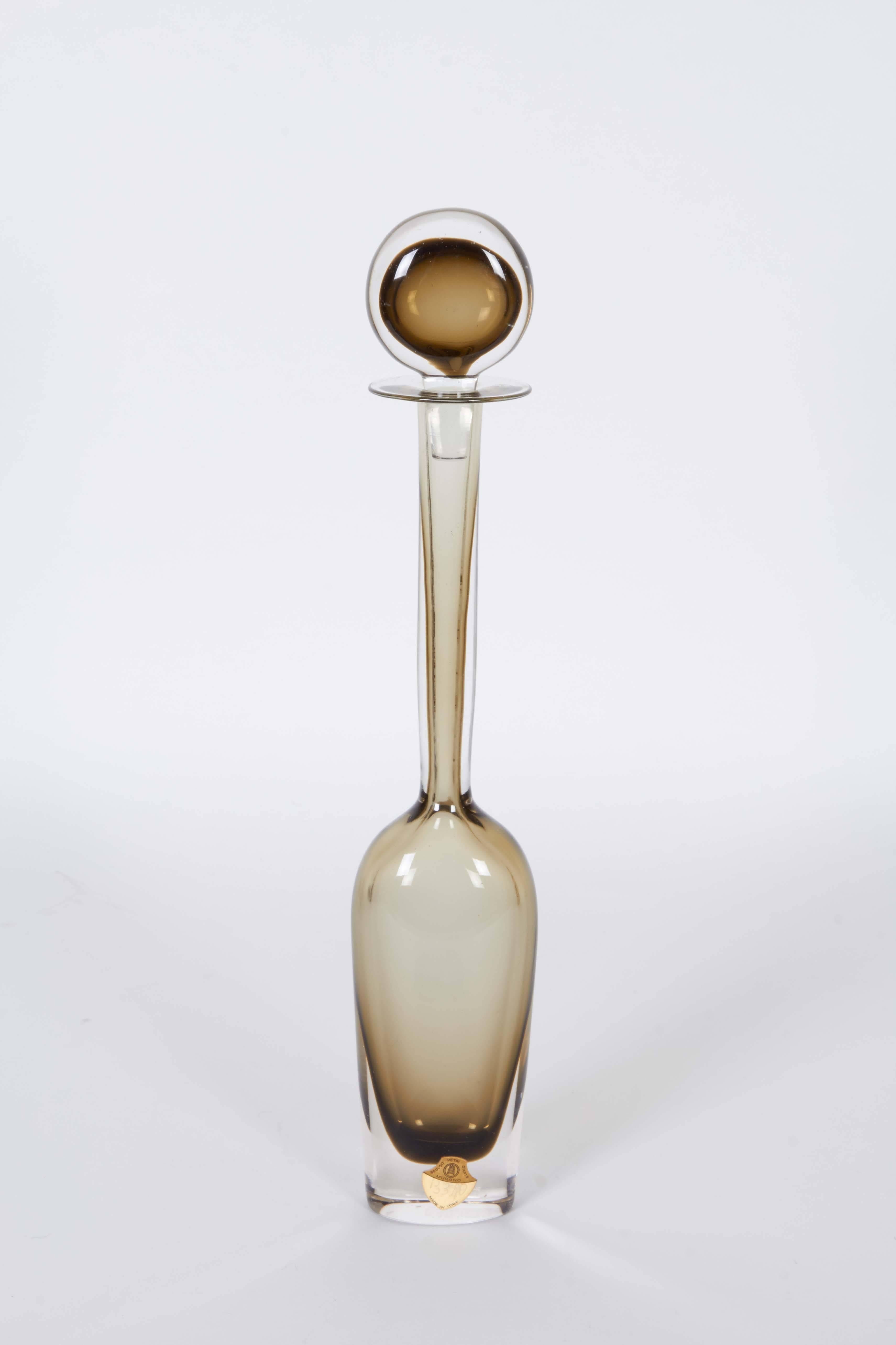 An Italian Murano glass decanter by designer Flavio Poli for Seguso Vetri d'Arte, produced circa 1960s, in warm gray cased by clear Sommerso layer, with lollipop stopper on long tapered neck and flared rim. Markings include original label [Seguso