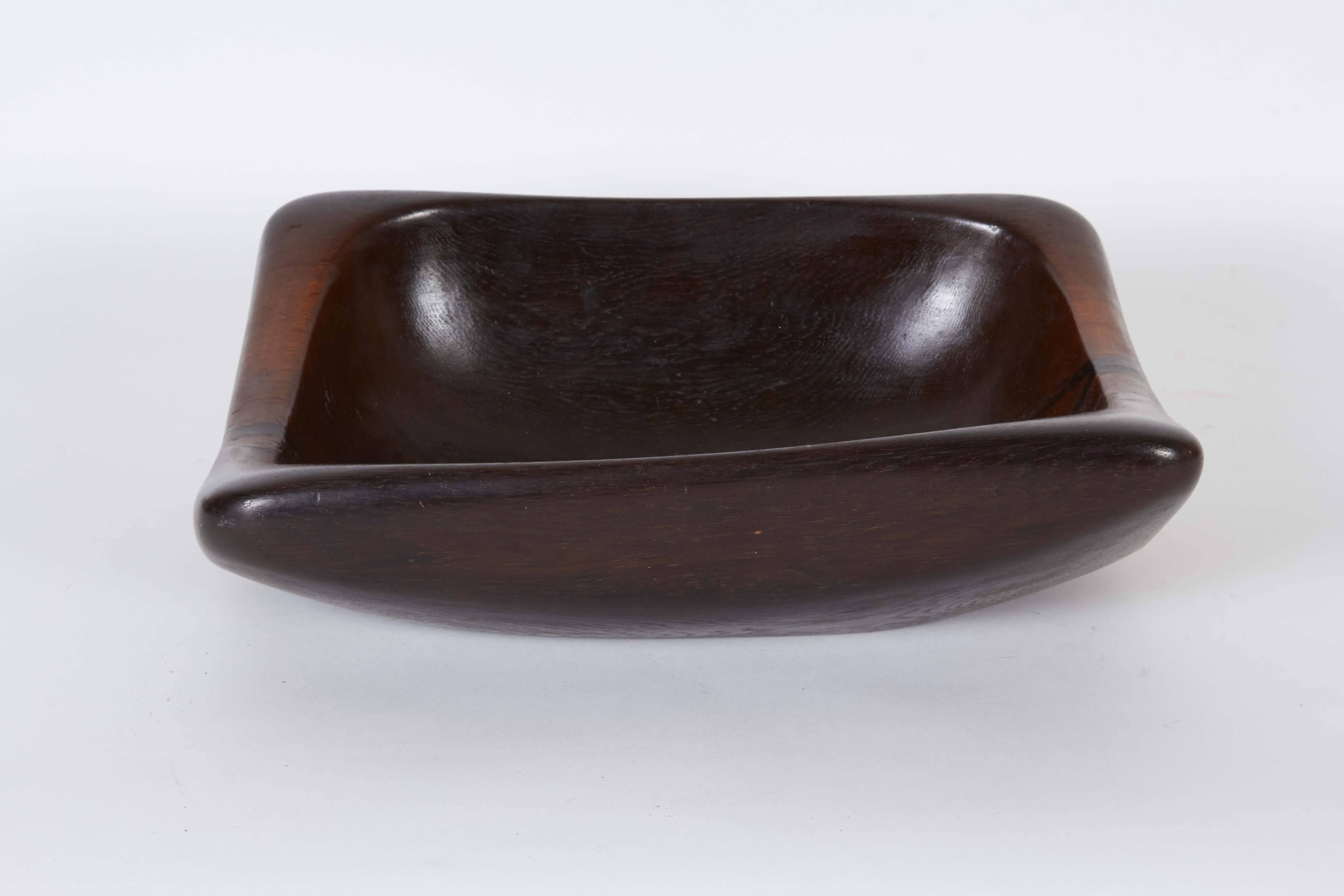 A bread serving bowl, of square form with rounded corners, crafted of rich carved hardwood. Very good condition, minor wear to base.

10936