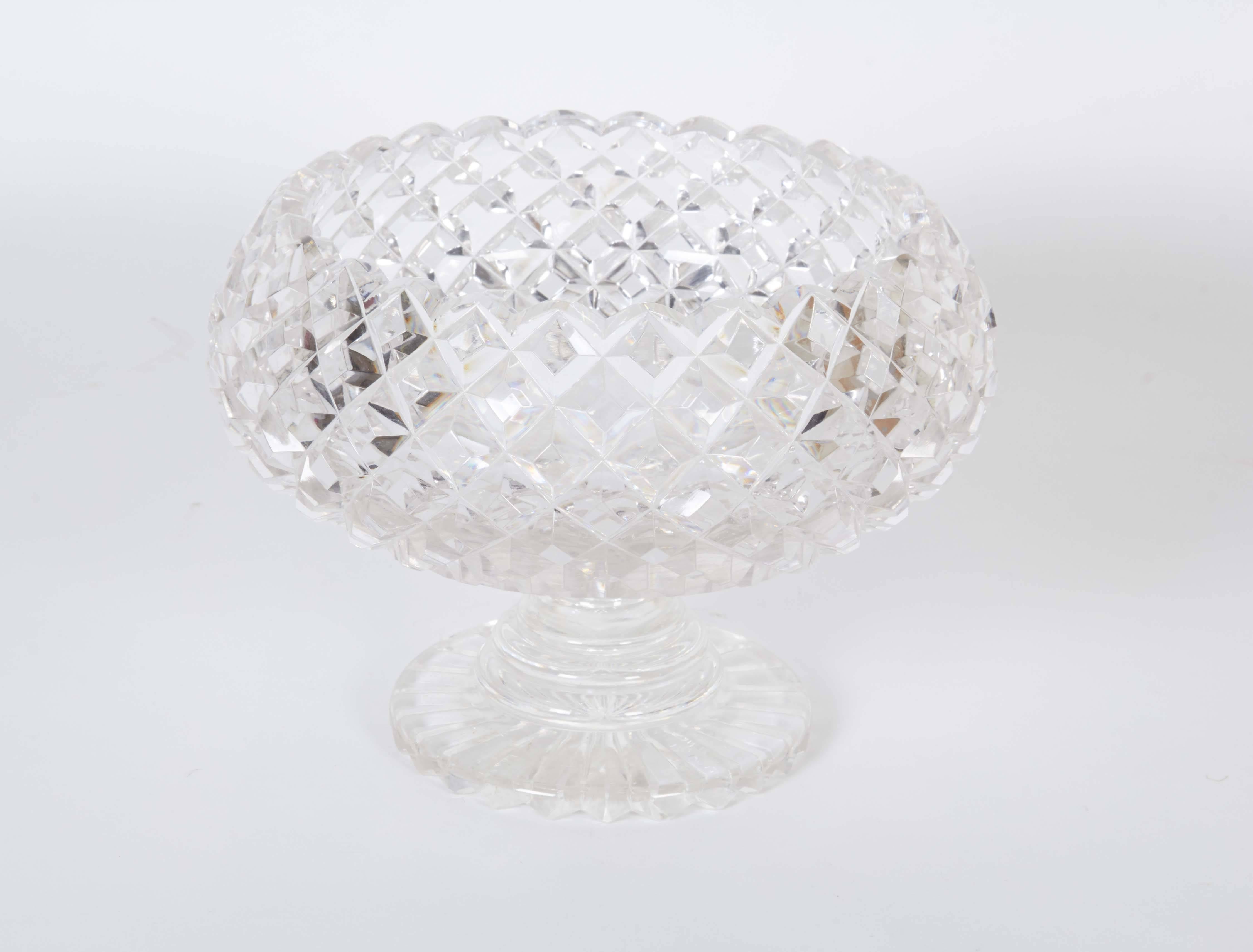 A pair of cut crystal compotes (or footed bowls), with scalloped edge and beveled diamond cut crosshatch patterns, each raised on single round stepped base. Very good condition, minuscule wear to bases consistent with age and use.

10938