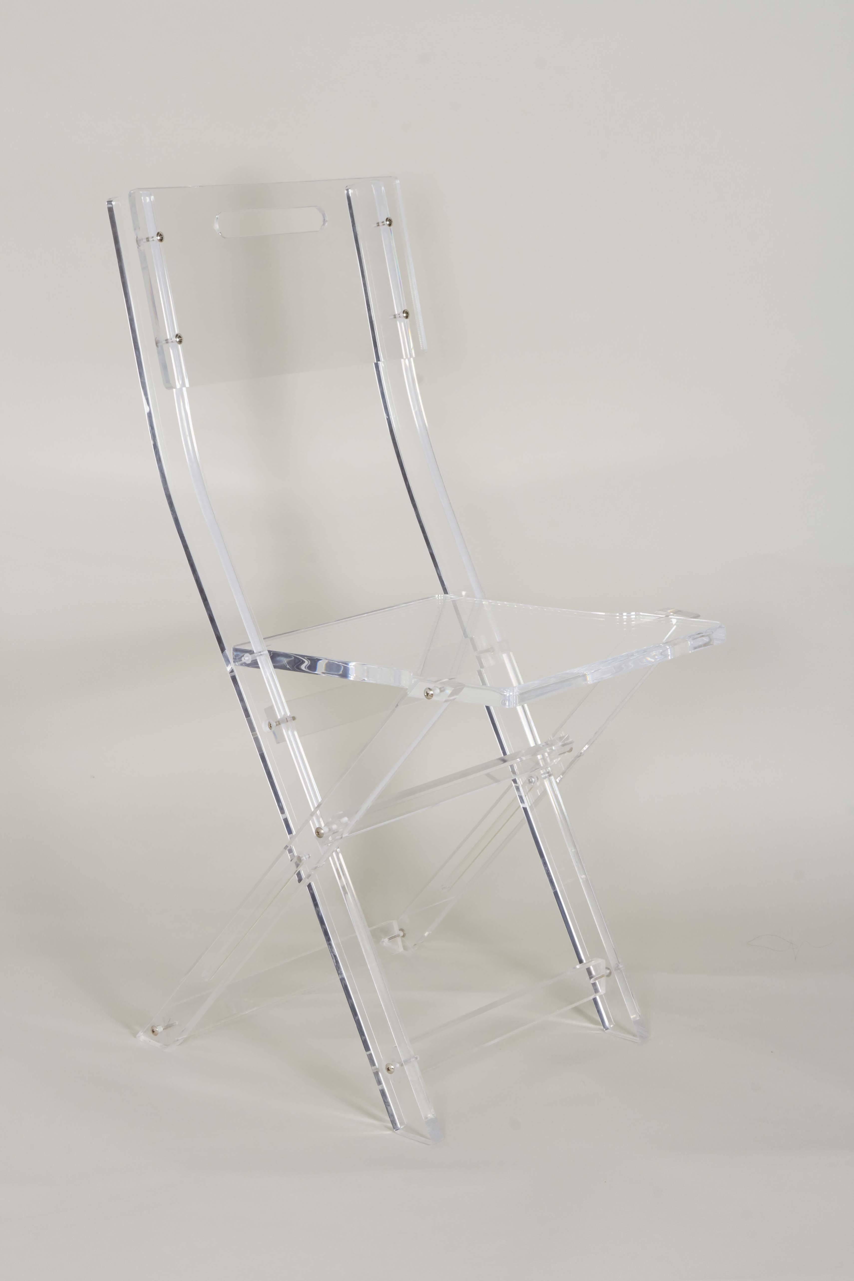 A vintage game table and set of four folding side chairs, manufactured in the United States, circa 1970s, the arrangement entirely in Lucite, each chair on Campaign style x-base. Very good vintage condition, consistent with age and prior use.

10899