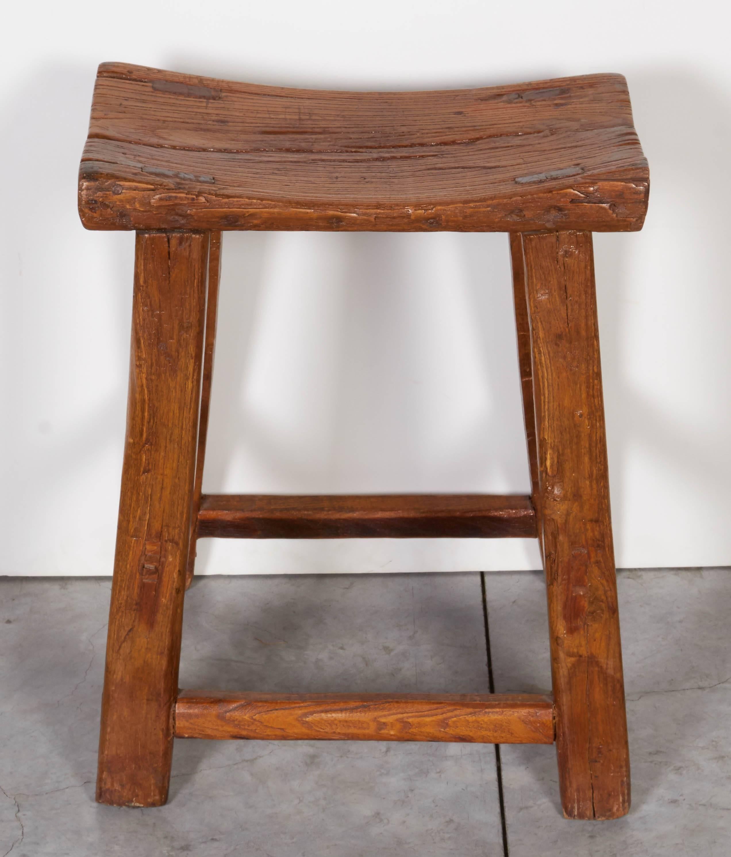 A graceful and classically shaped antique Chinese stool with great patina that reflects it's century of history and use. This beautiful stool not only provides seating, but works well as an object in a powder room to display folded towels. From