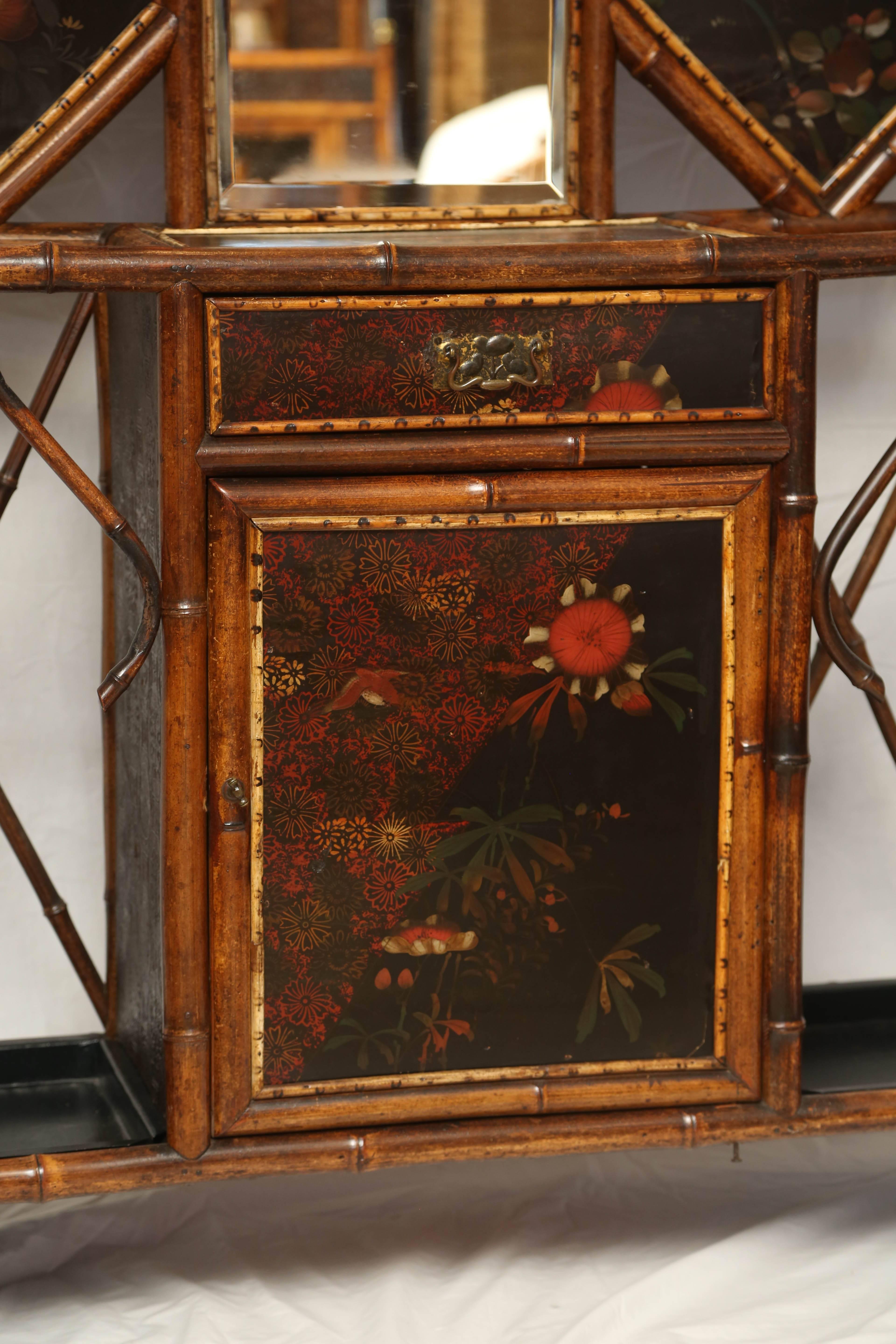 Rare and beautiful 19th century English bamboo hall stand with one drawer and one cabinet and with Japanning panels.