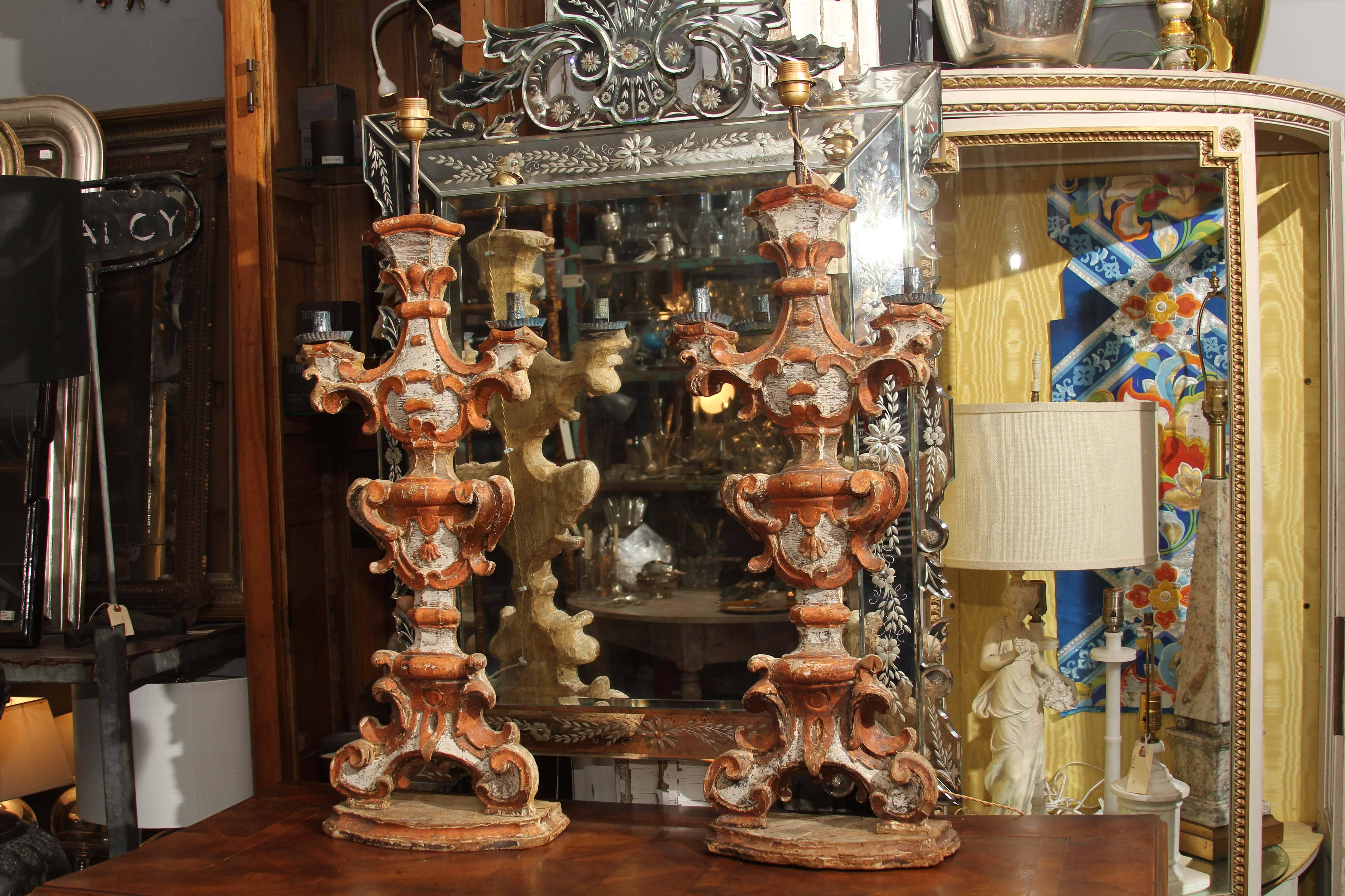 18th century Italian hand-carved wood candlesticks with aged finish of coral and white with remnants of silver two metal candle holders remain on each; the upper was removed to house the European bulb and wiring.
Grand size and beautiful patina and