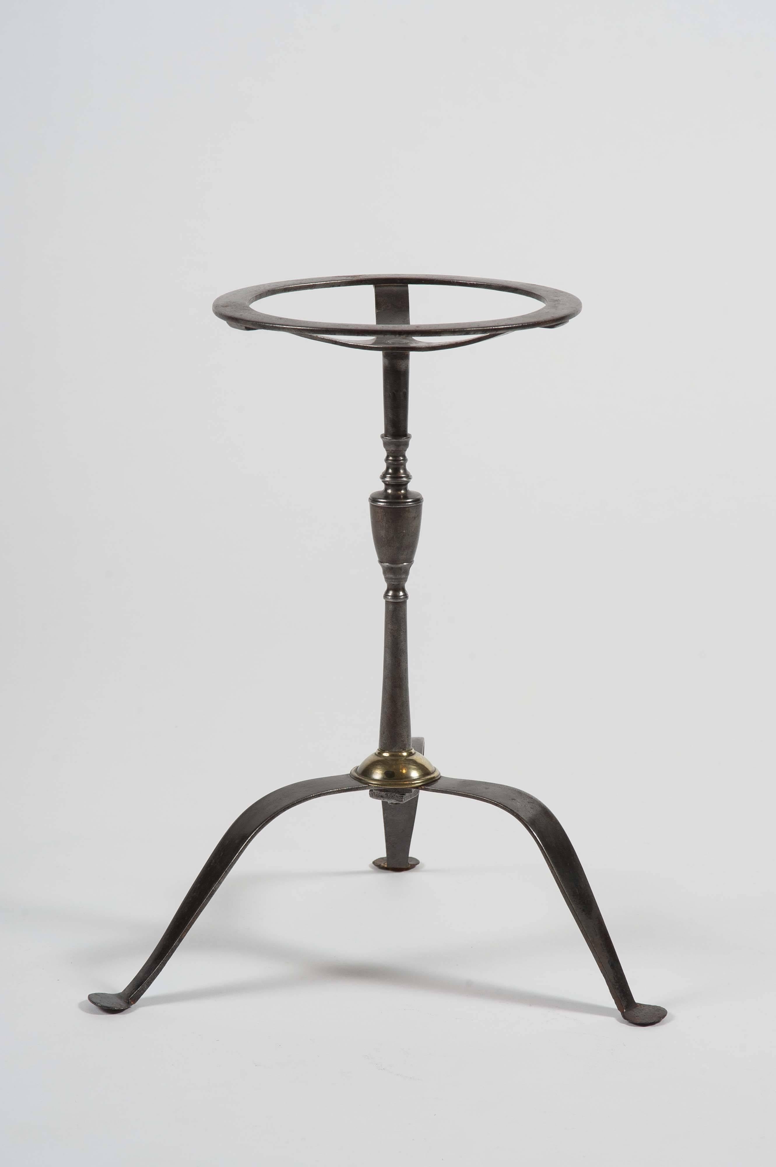 A George III period steel trivet with a beautifully turned “vase” stem and pierced circular top on tripod legs. Made to hold plates or kettles but an ideal ice bucket Stand. Diameter of top: 7.75
