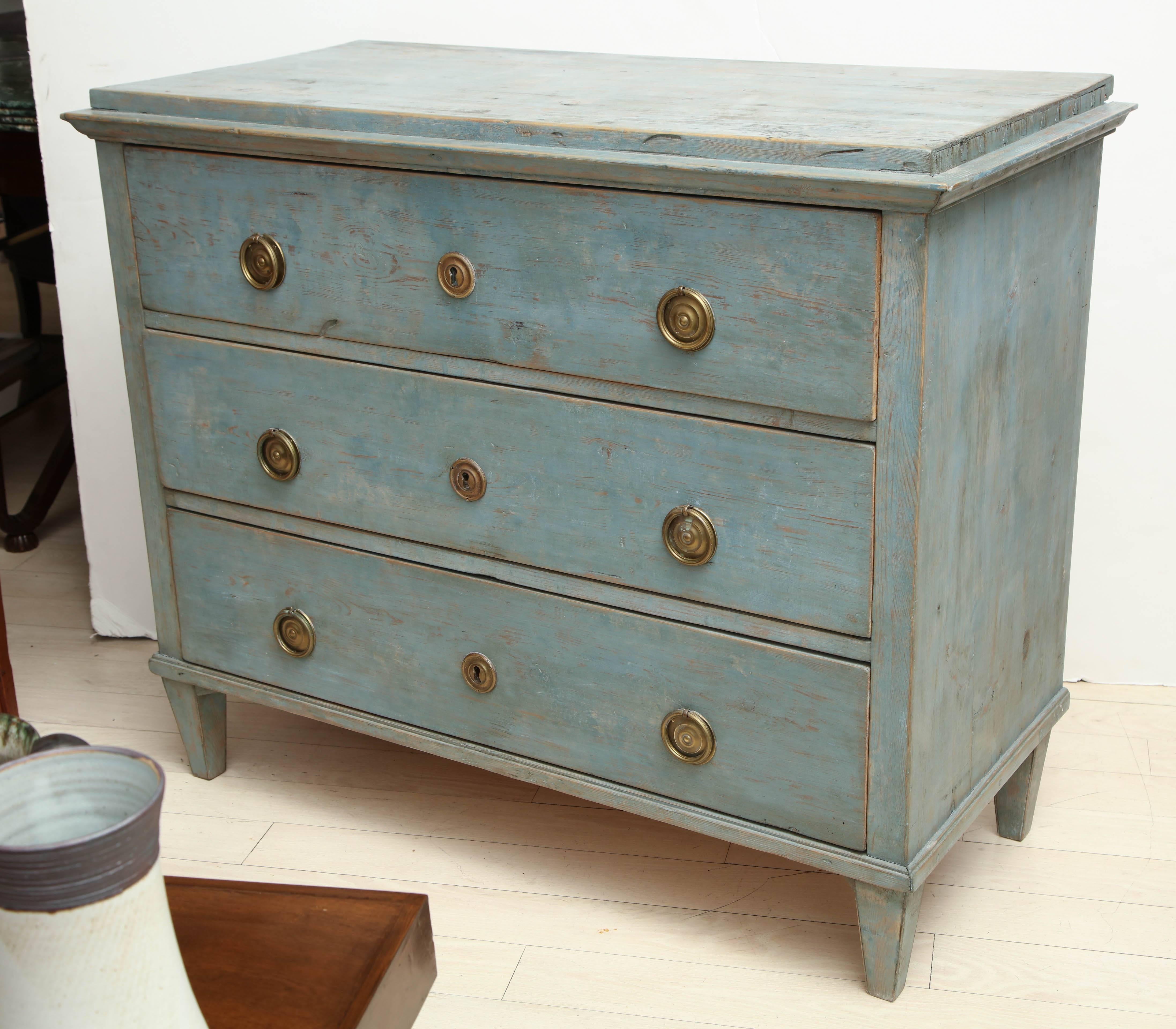 19th century blue painted pine commode with three drawers and brass pulls.