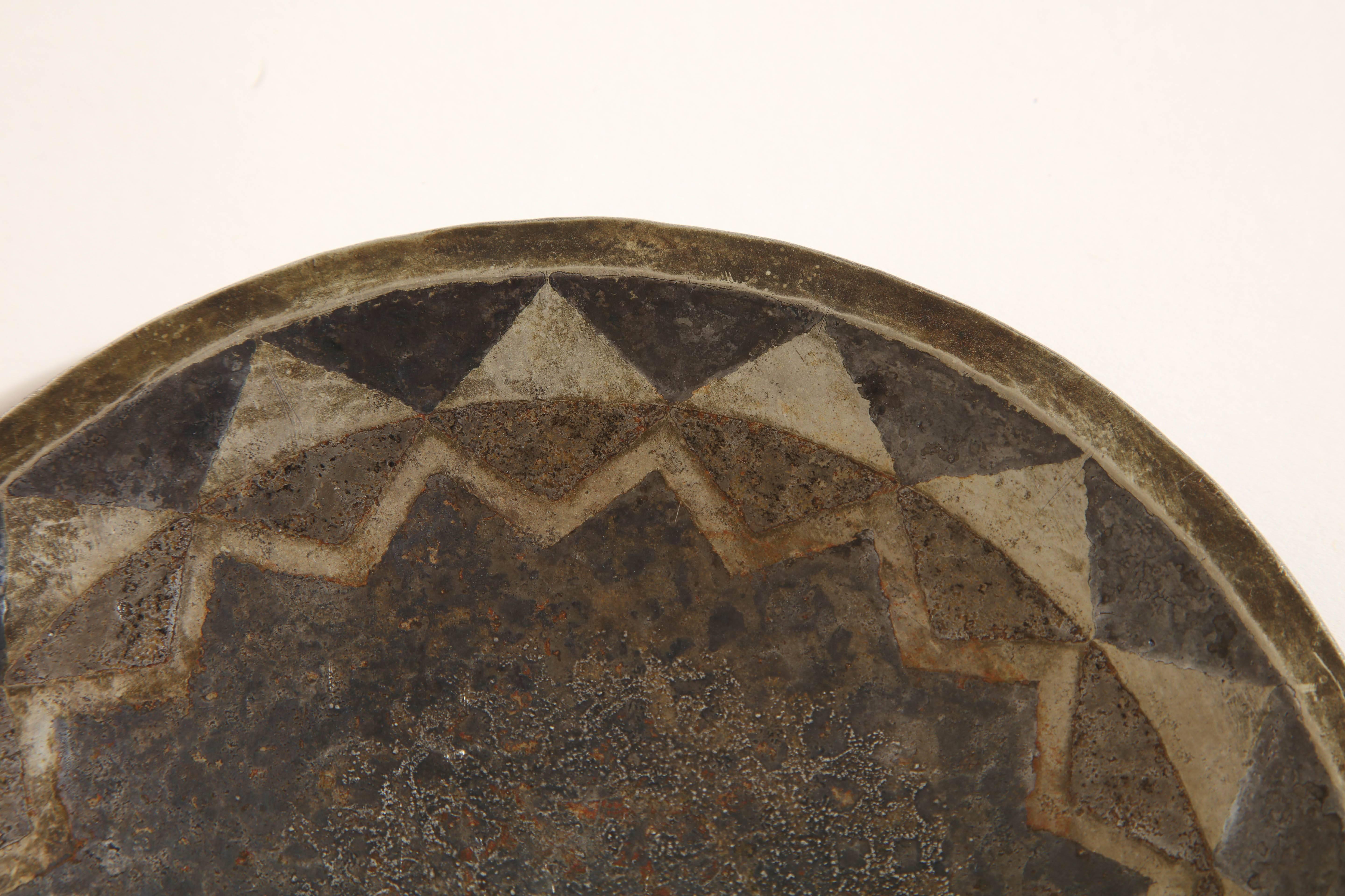 This slightly hollow circular coupe is decorated with triangular and zigzag maillechort inlays on a fire patinated richly nuanced silver background. 

Inscribed CL-LINOSSIER / A9 underneath on rim

Literature:
Jean Gaillard, 