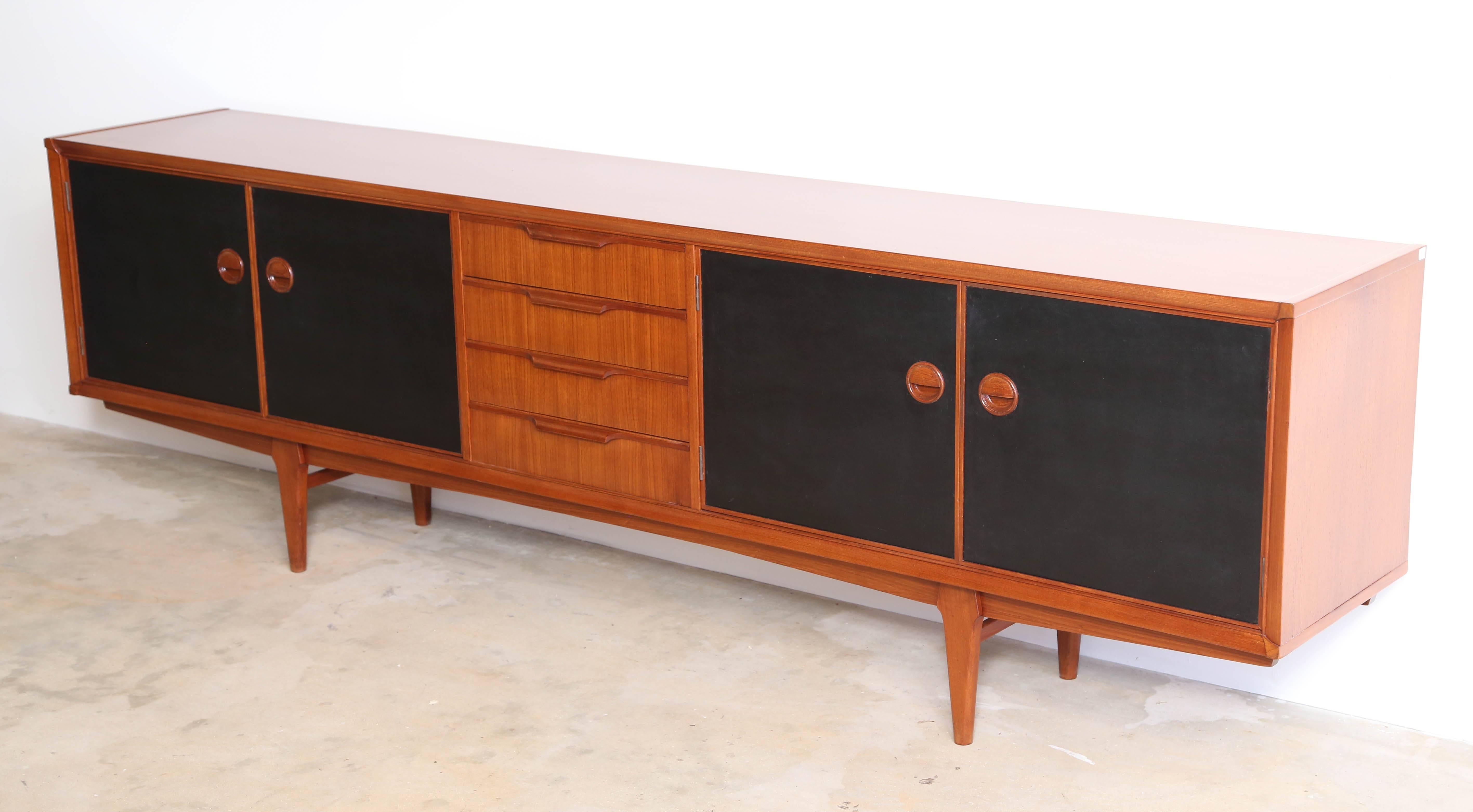 Low Danish Mid-Century credenza, in teakwood.
In the style of Ib Kofod -Larsen.
Very refined craftsmanship, teakwood handles carved in solid teak, the same for the four round handles of the four doors.
A delicate and refined detail at each angle