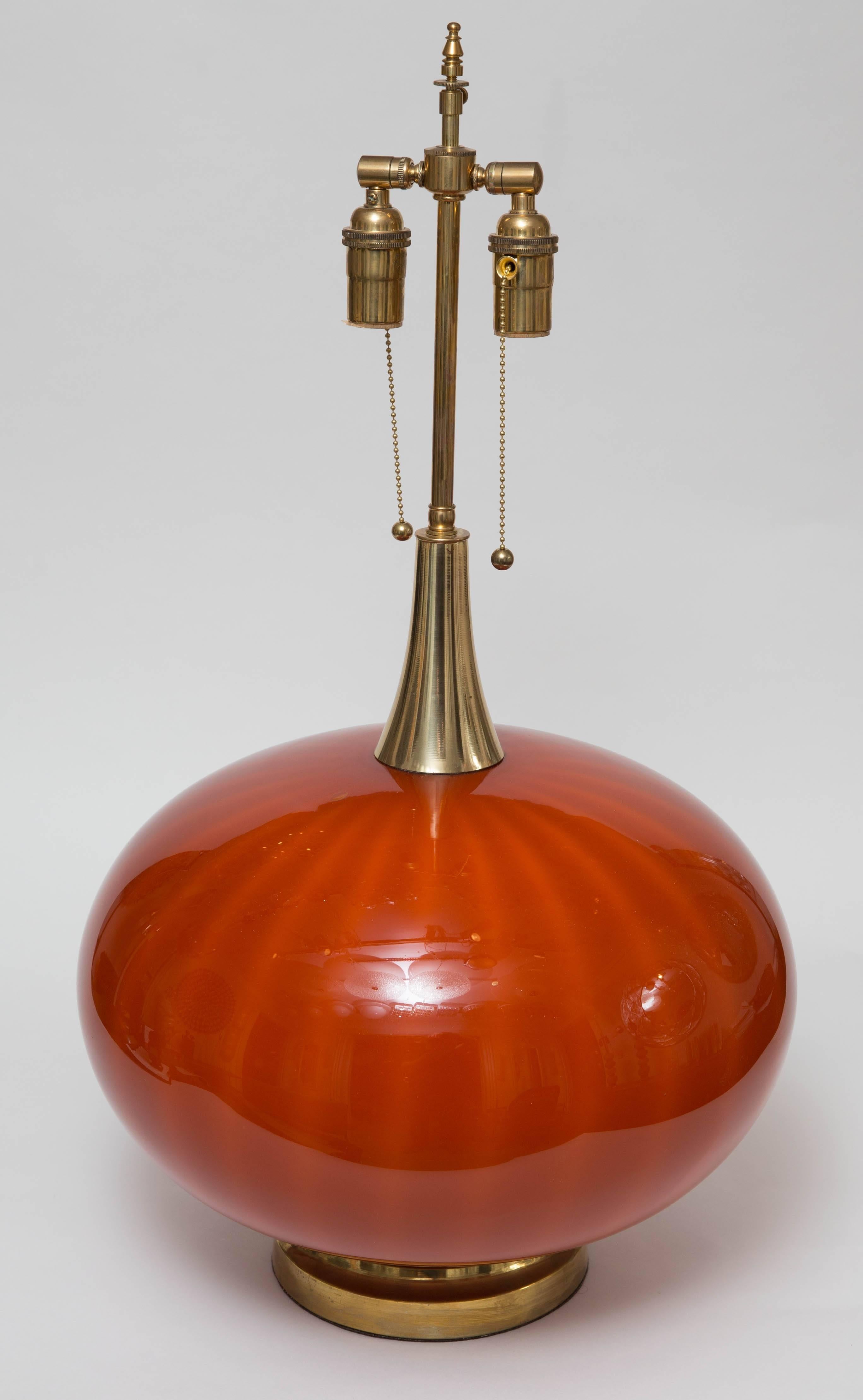 Pair of orange Murano glass orb shaped lamps with brass detail.